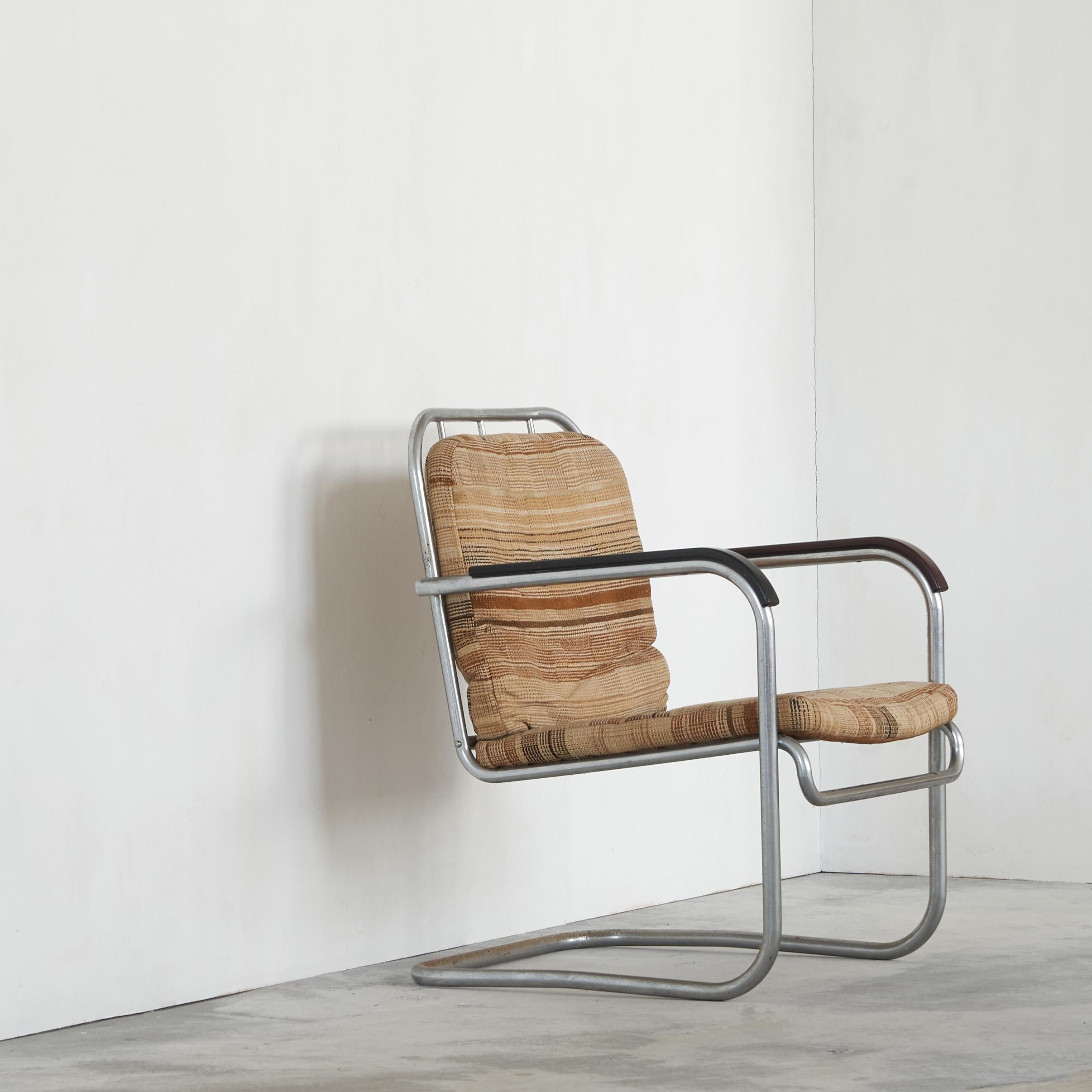 Belle chaise tubulaire très originale des années 1930. Un design tubulaire simple et direct avec des accoudoirs en bakélite, mais très moderne pour l'époque. L'arrière est intéressant en raison du rythme des tubes verticaux. 

La tapisserie