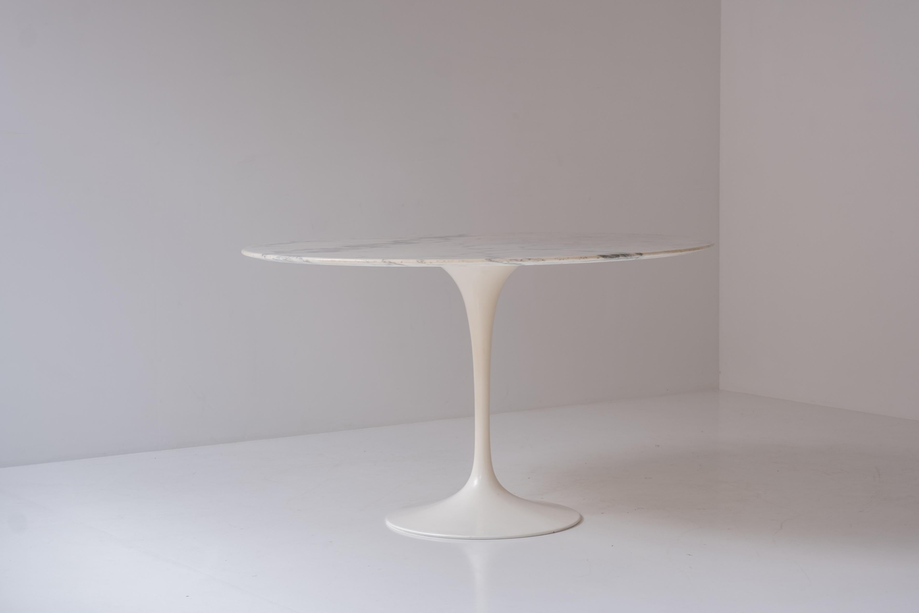 Early tulip round dining table by Eero Saarinen for Knoll International, Italy 1970s. This iconic piece features a beautiful Arabescato marble with a white base. This piece remains in a very good condition with only minor wear. Signed underneath