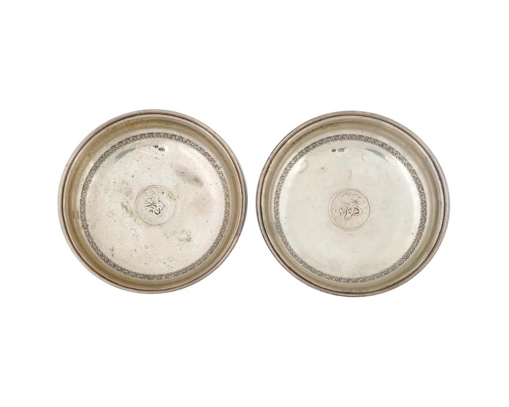 A pair of antique Turkish silver serving plates also known as the coin dish. Turkish Republic era, ca. 1920s to 1930s. Round dishes with high rims. Etched acanthus leaf ornament along the boarders. The center features an imprint of an Ottoman kurus