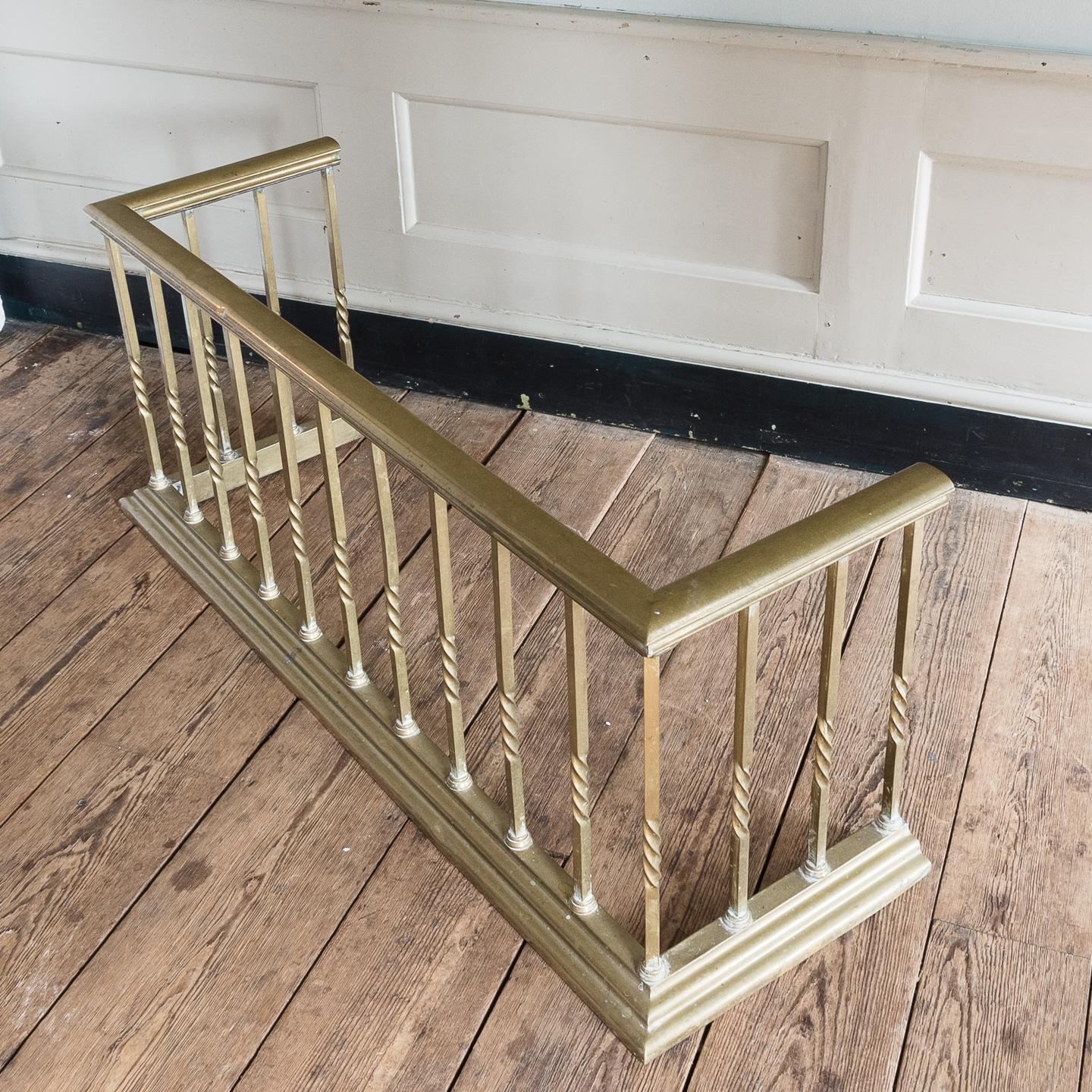Early 20th century English brass club fender, the brass seat rail on square section supports, each wrythen to the centre.