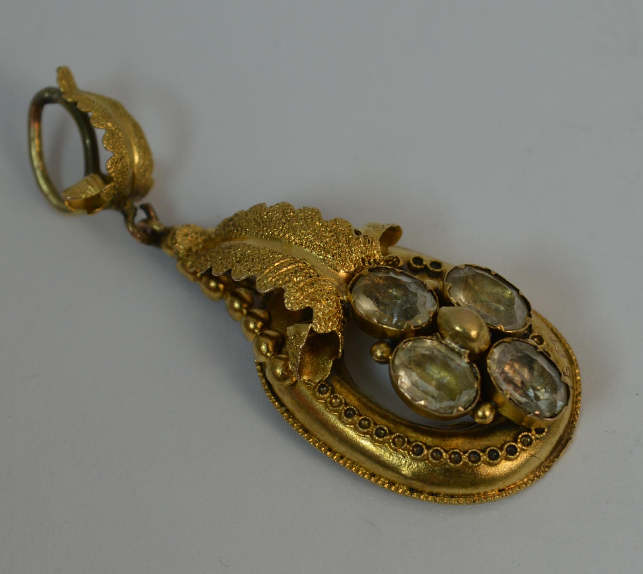 
A superb Victorian era pendant. 

15 carat yellow gold example.

Designed with four oval white stones in closed backs. The gold designed with a fine border pattern and leaf shape to top and bale.

CONDITION ; Very good for age. Clean gold with