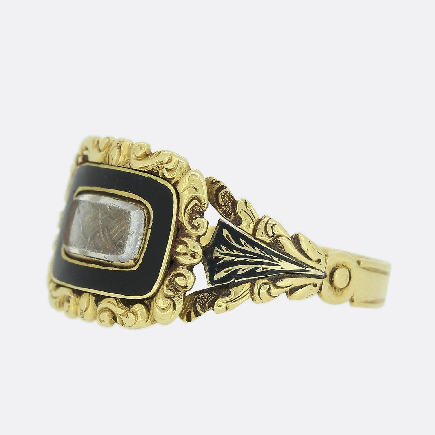 This is a wonderful 18ct yellow gold mourning ring from the late Georgian era. The ring has been set with a central rectangular window that features a small locket of hair with a border of black enamel. Both the face of the ring and the shoulders of