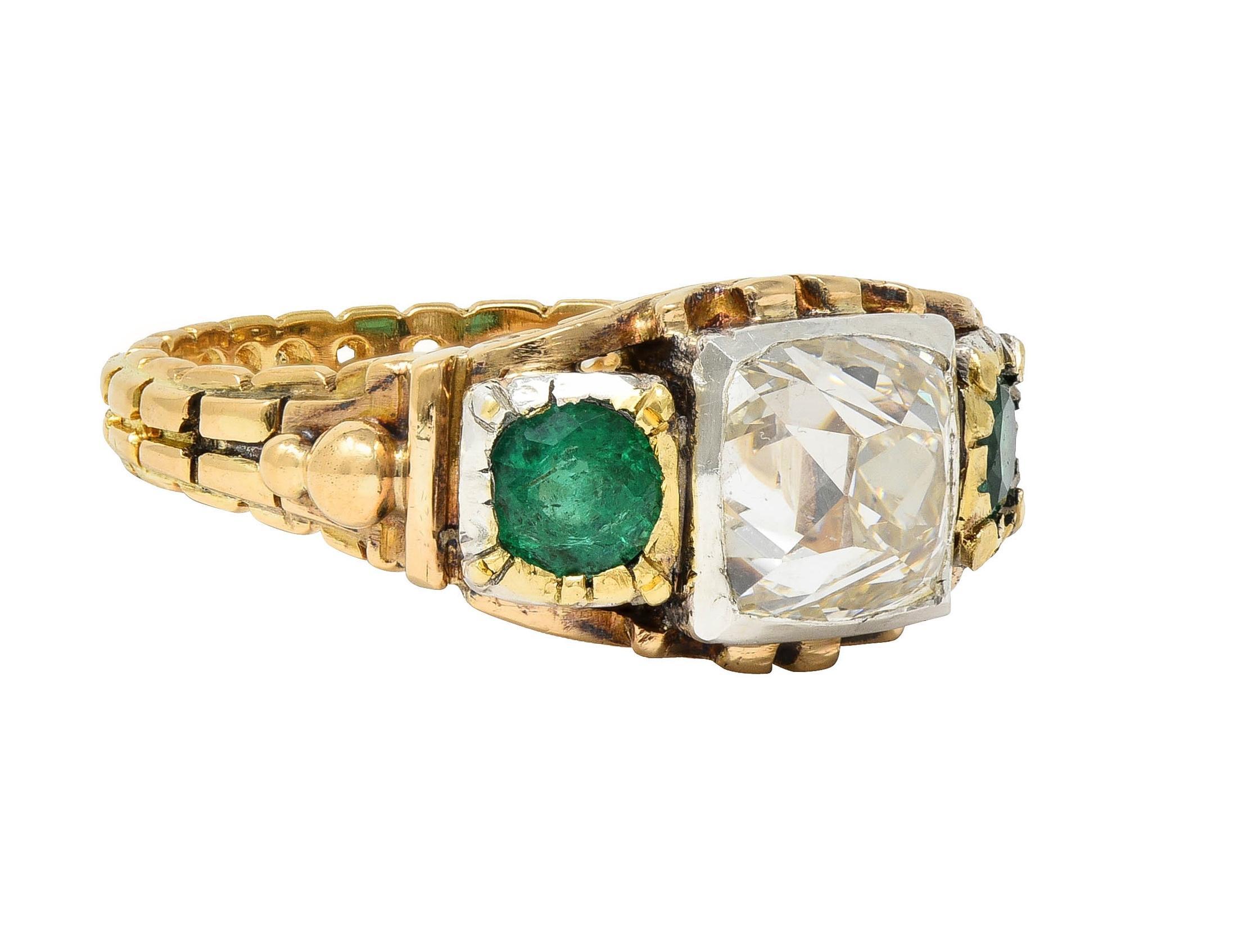 Centering a Peruzzi cut diamond weighing approximately 3.20 carats 
J color with VS2 clarity - set in a silver-topped square form bezel 
Flanked by round cut emeralds in silver-topped square bezels
Weighing approximately 0.72 carat total