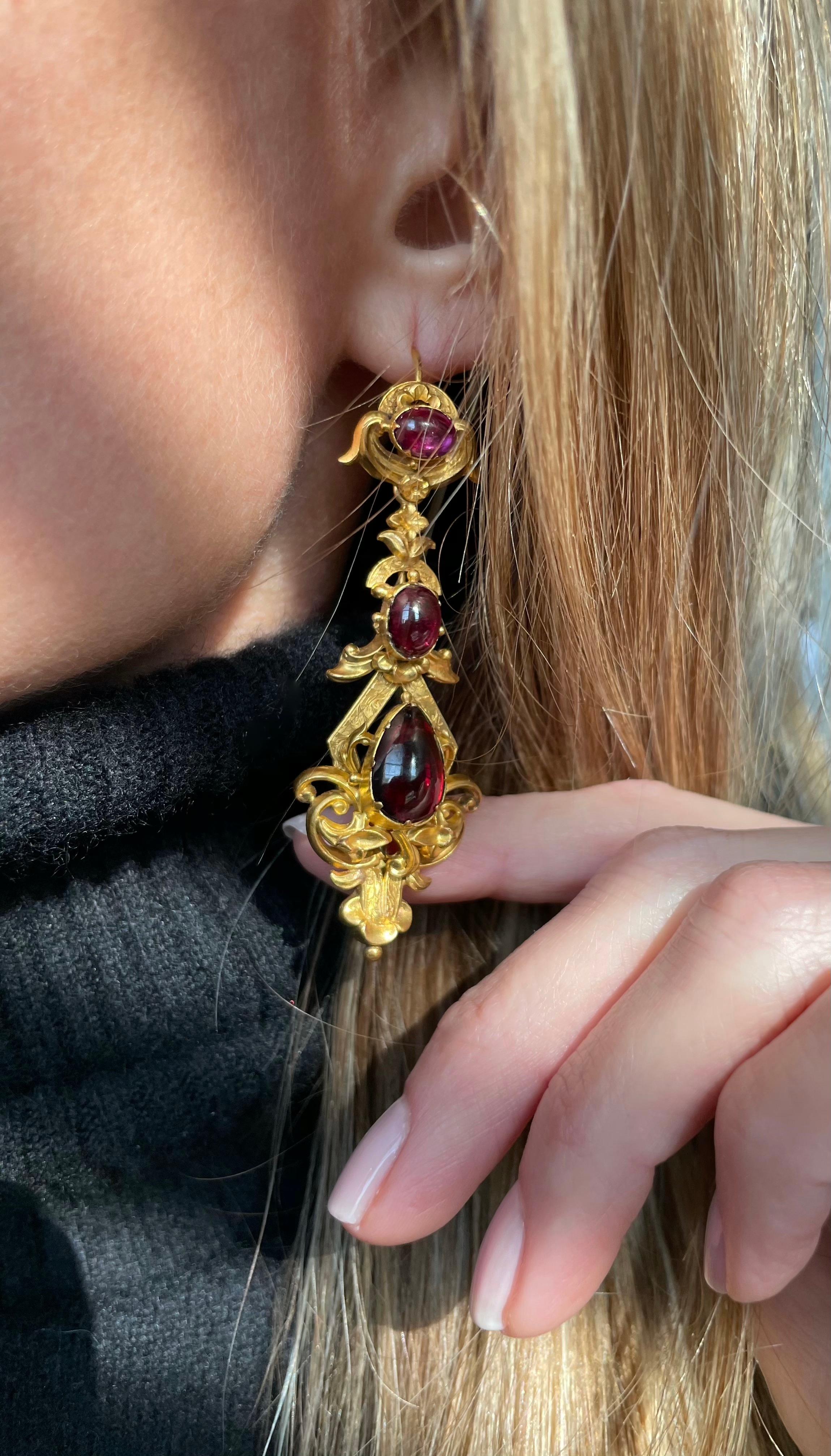 This delightful and incredibly scarce Georgian  demi-parure contains a matched suite of jewels, beautifully crafted in a bloomed 15k gold with glowing, foil backed almandine garnet carbuncles. The back of the stomacher contains a small glass covered