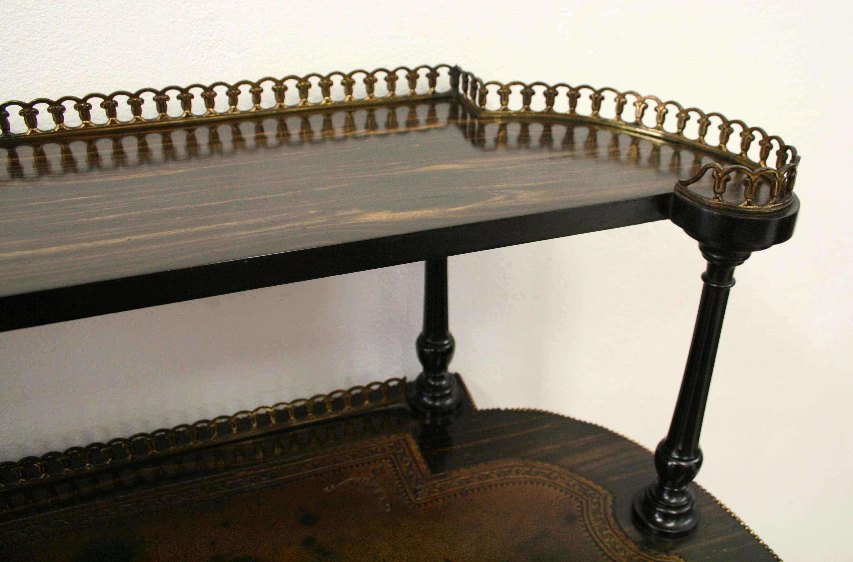 Unusual coromandel writing table, circa 1860. This freestanding writing table has a raised section with a wraparound brass gallery, and is held in place by four turned, ebonized, tapering and reeded columns. At the base at the back is another brass