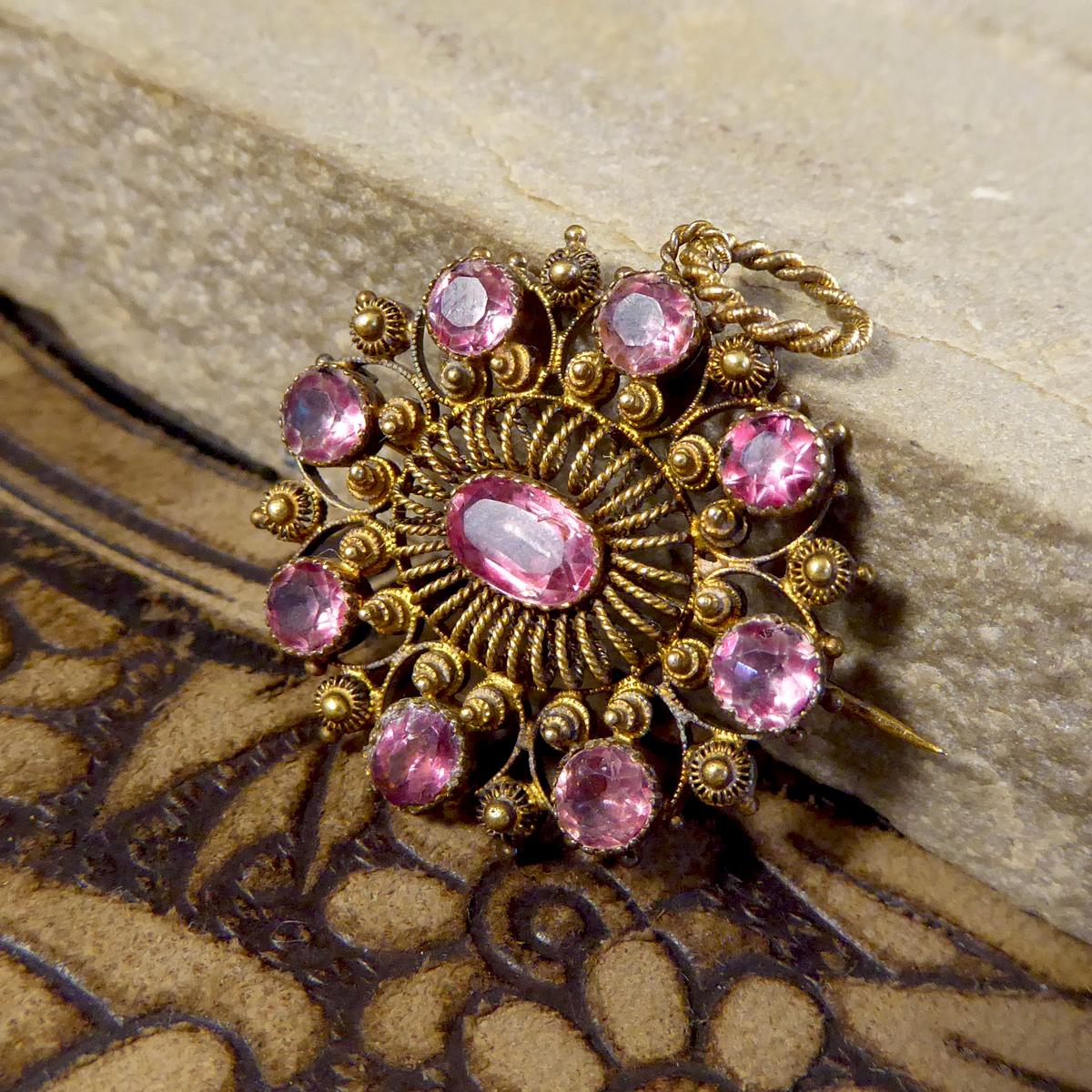 This lovely pendant/brooch is showing such quality aesthetic from the Early Victorian era. It is in a circular shape and set with pink gemstones that have foiled behind so as to give them a translucent effect. In such lovely condition and wearable,