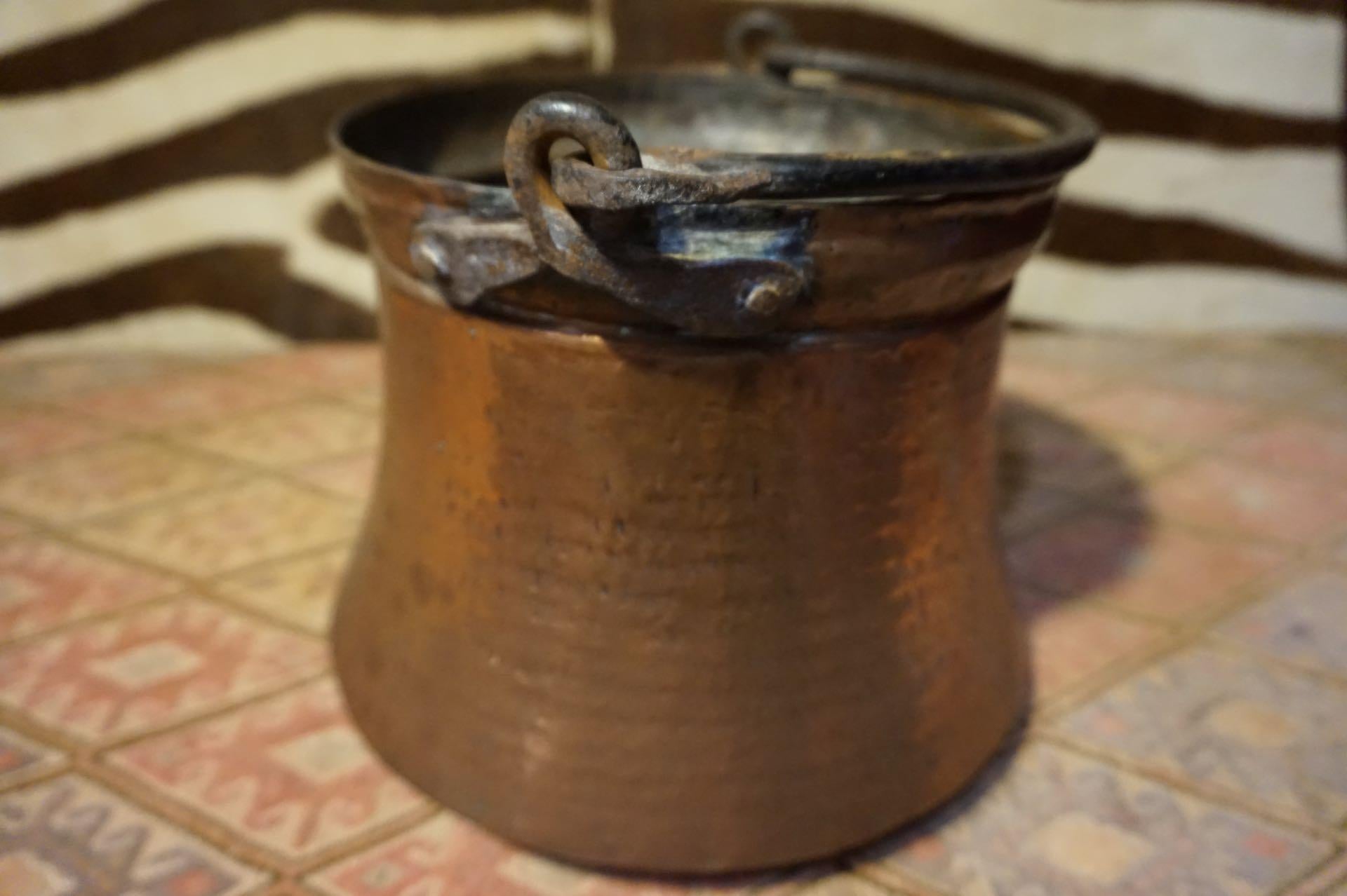Top notch blacksmithing with seamless hammered copper work. Signs of oxidization inside with hand hammered marks, rivets and curved and tapered handle all point to good age on this concave and beautifully constructed bucket. This kind of workmanship
