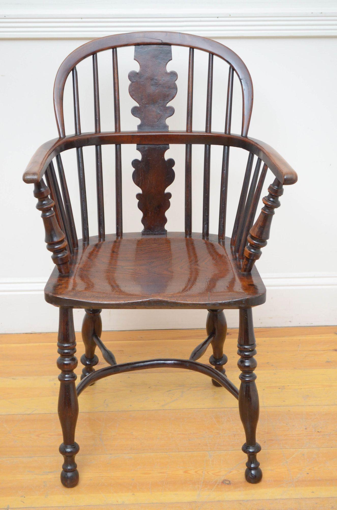 St042 Early Victorian Windsor chair in ash and elm wood, having arched back with centre splat flanked by spindles, open arms and ash seat, standing on turned legs united by crinoline stretchers. This antique chair is in home ready condition.
