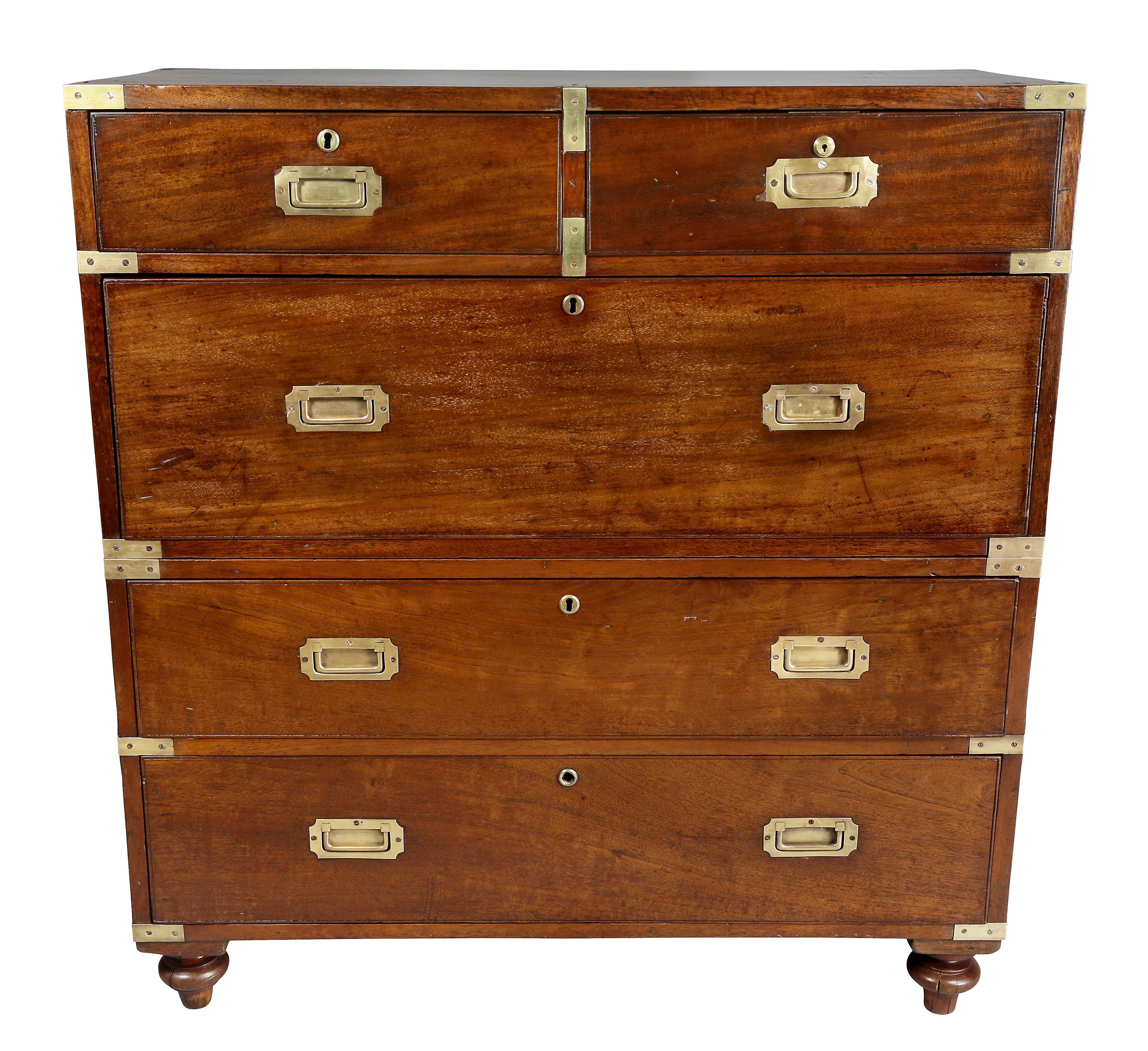 With rectangular top with brass corners over two drawers one fitted as a desk over three drawers, raised on original toupie feet.