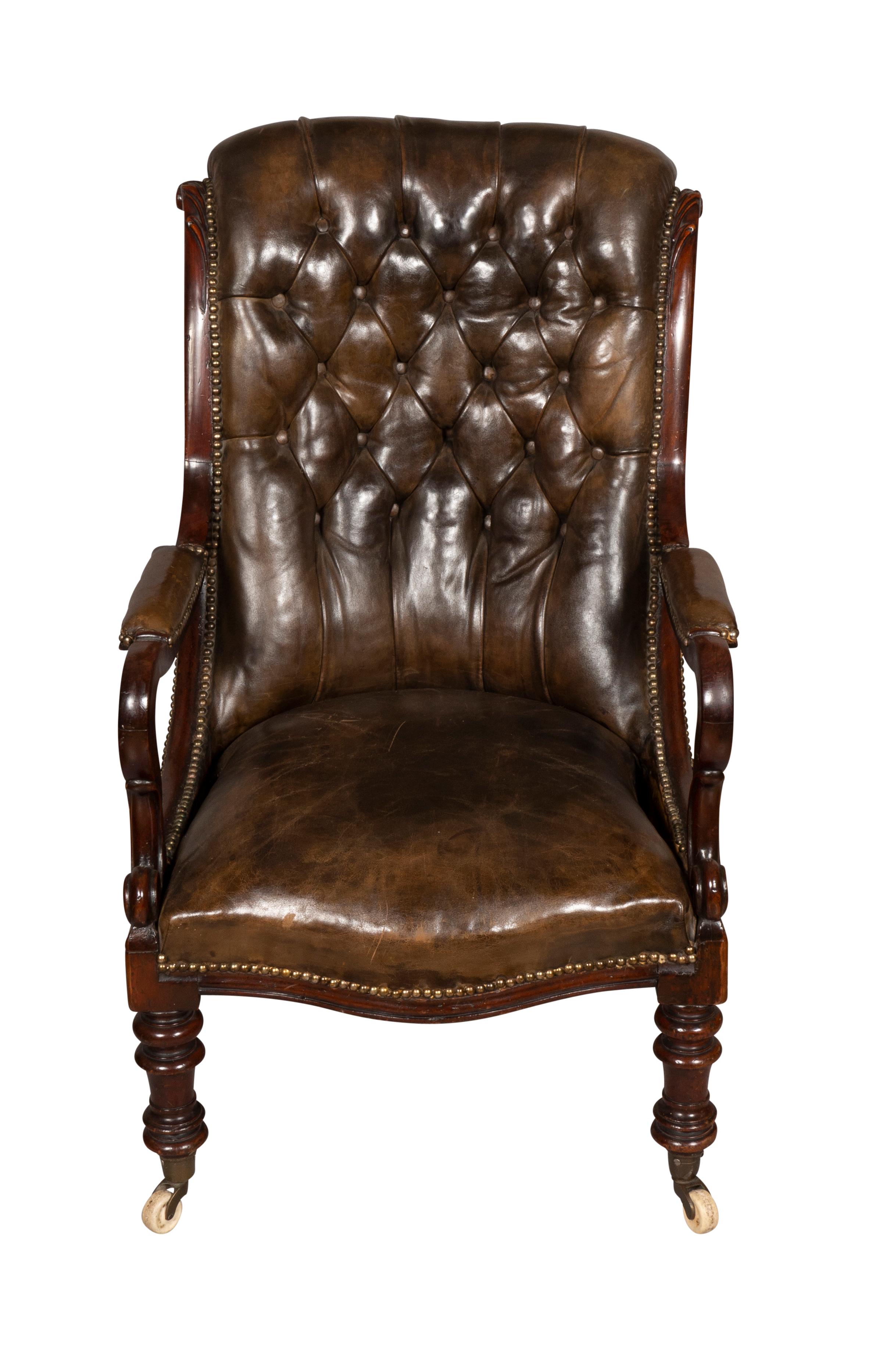 With tufted brown leather upholstery raised on turned tapered legs with casters.