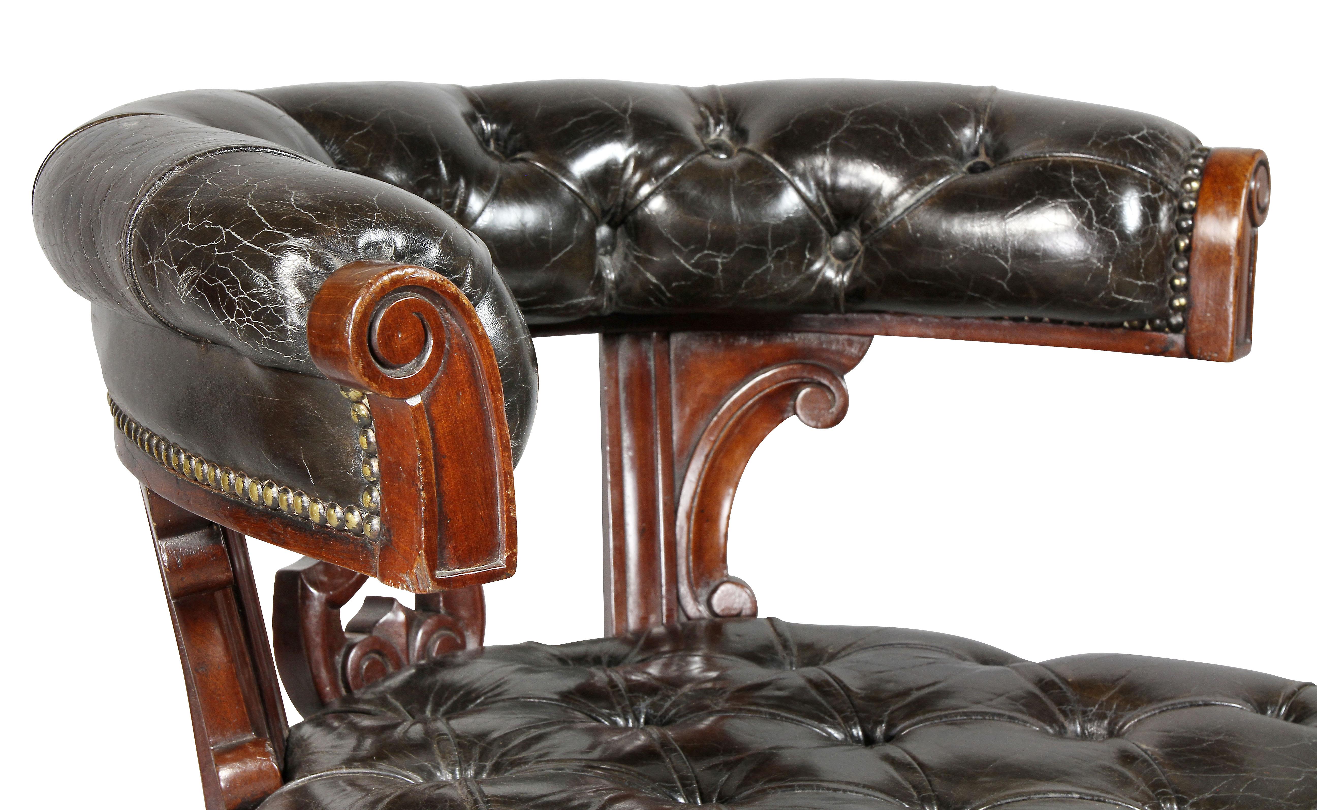 With tufted leather horseshoe back over a pierced splat, seat raise on turned tapered legs, casters.