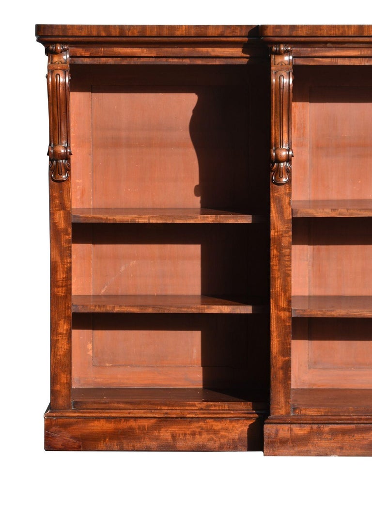 For sale is a good quality early Victorian mahogany bookcase. Breakfront in form, the bookcase has three separate sections, each with two adjustable shelves flanked by carved corbels. The bookcase stands on a plinth base and is in very good