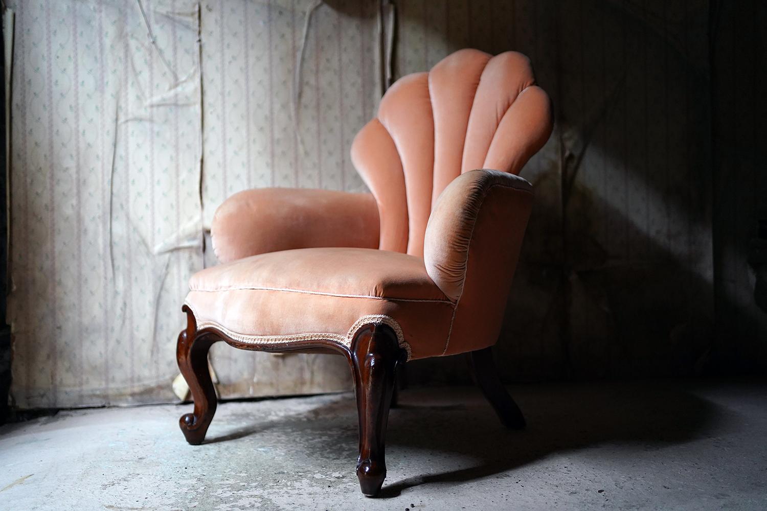 The shell or scalloped shaped parlour chair, in a peach coloured fabric with single piping, having a five fanned back with shaped arms and shaped apron to cabriole legs, the whole surviving from the second quarter of the nineteenth century.

In
