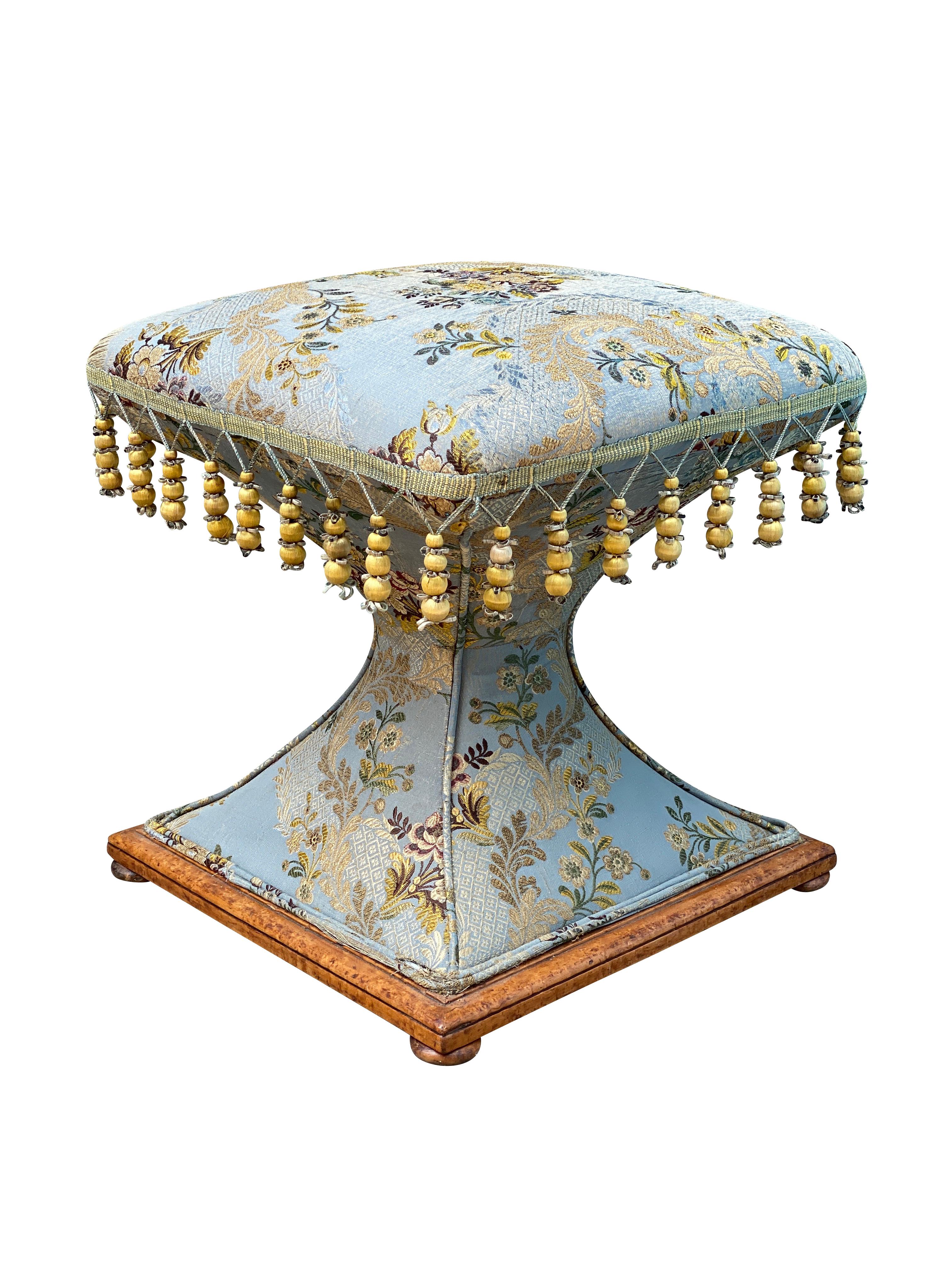 Square upholstered hourglass form. Wood trim on base with wafer feet. Slightly worn silk upholstery.