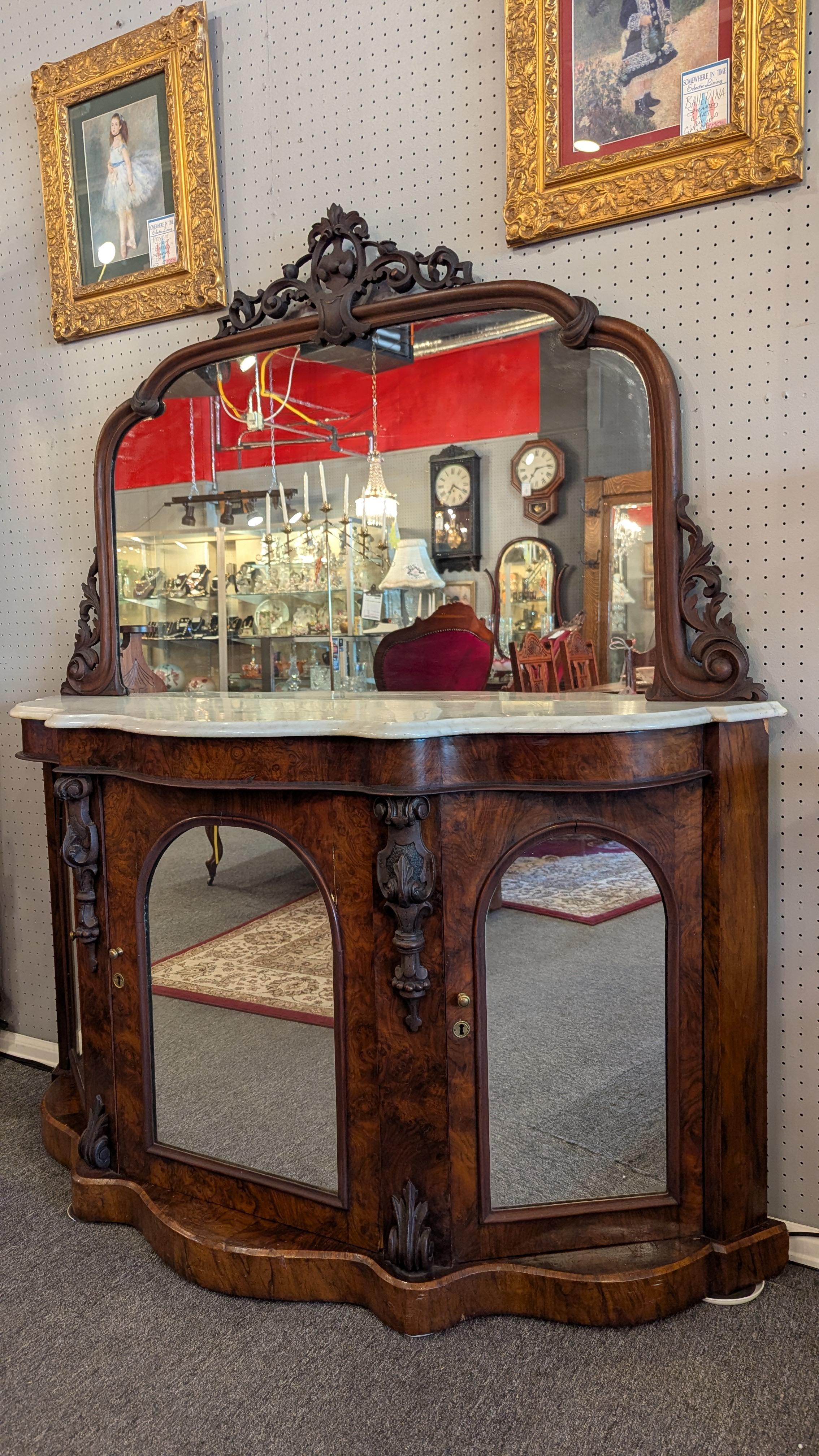 Here is an 1850's early Victorian marble topped console with beautiful grain mahogany cabinet and large arched mirror.  Three arched mirror lower doors used to see the hoop skirts of the time, lovely figured marble to match the curves of the