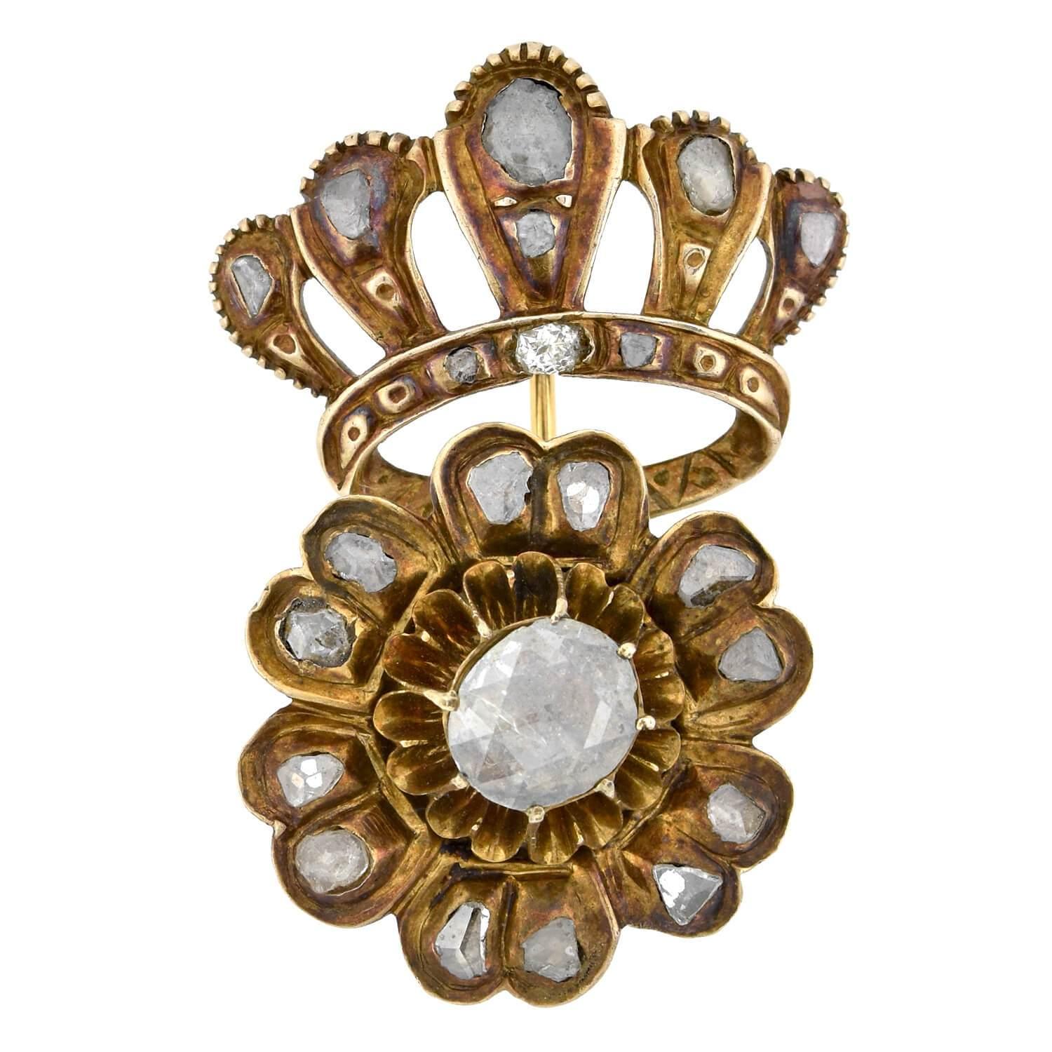A breathtaking and highly unique tremblé pin from the Early Victorian (ca1850s) era! This magnificent piece is crafted in rosy 12kt yellow gold and features a bold crown and a floral motif. A handcrafted open wirework crown is attached at the base