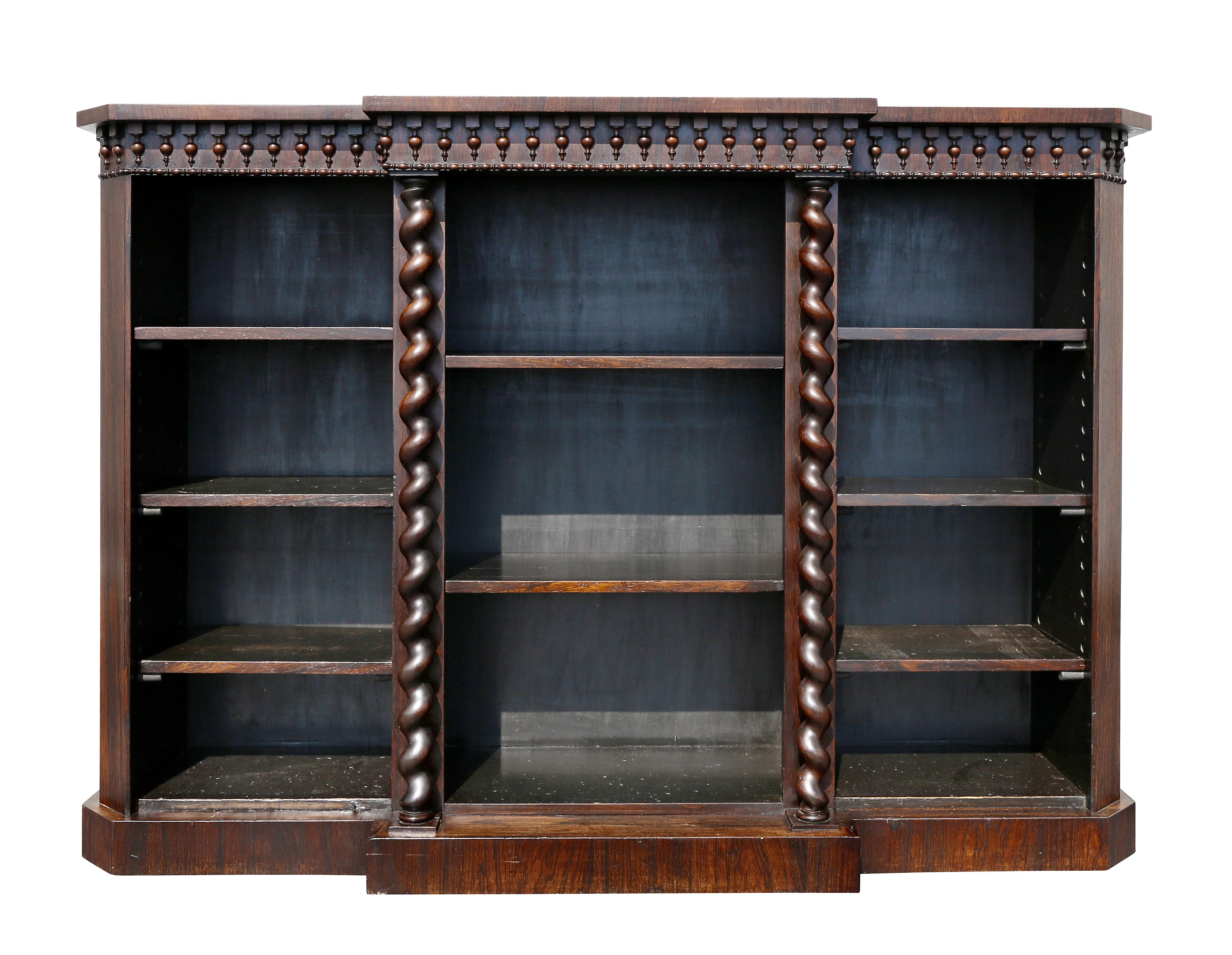 With rectangular breakfront form top over a frieze with bead and reel and pendant carving over a three-section bookcase with central barley twist columns. Adjustable shelves. Plinth base.