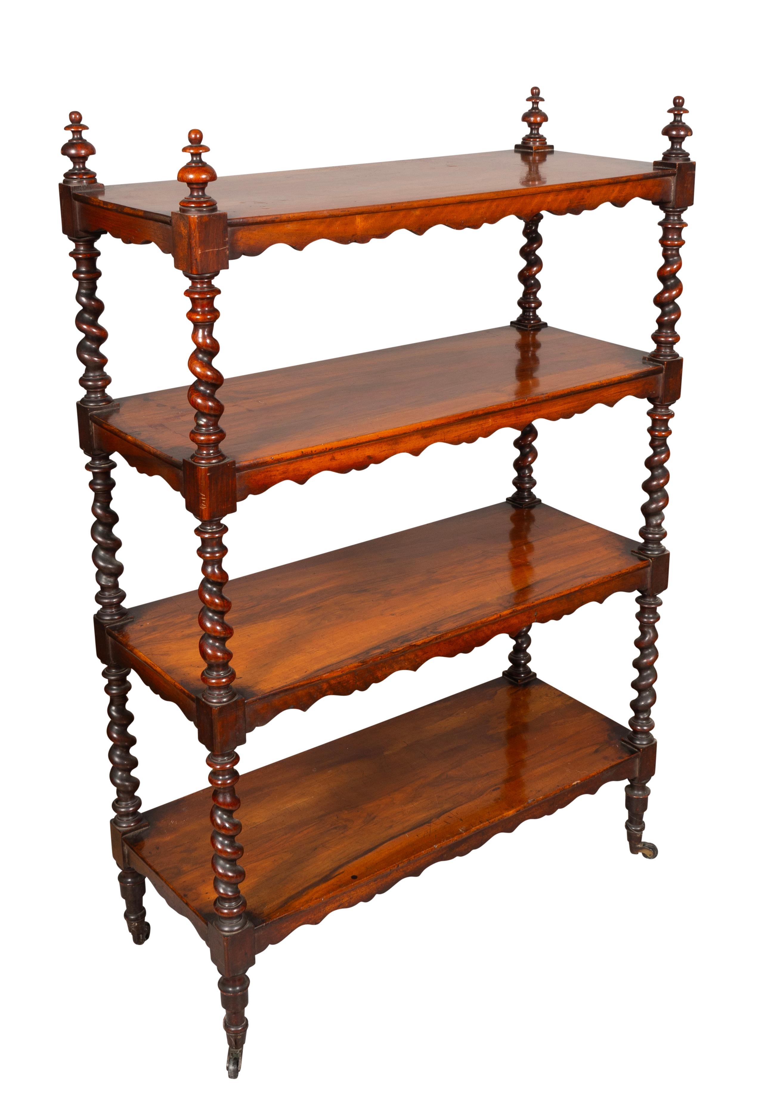 Rectangular top with corner finials over three conforming shelves supported with barley twist legs and uprights. Casters.