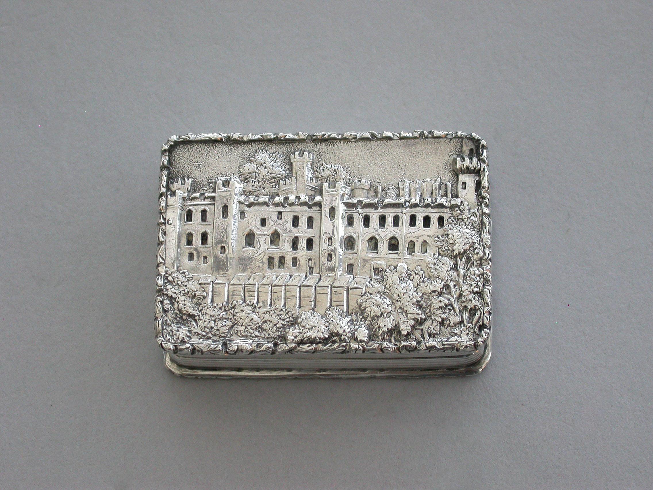 A very fine early Victorian silver 'Castle Top' Vinaigrette, of rectangular form with engine turned decoration to the base and reeded sides, raised foliate borders, the lid depicting a view of Warwick Castle in high relief, silver gilt interior with