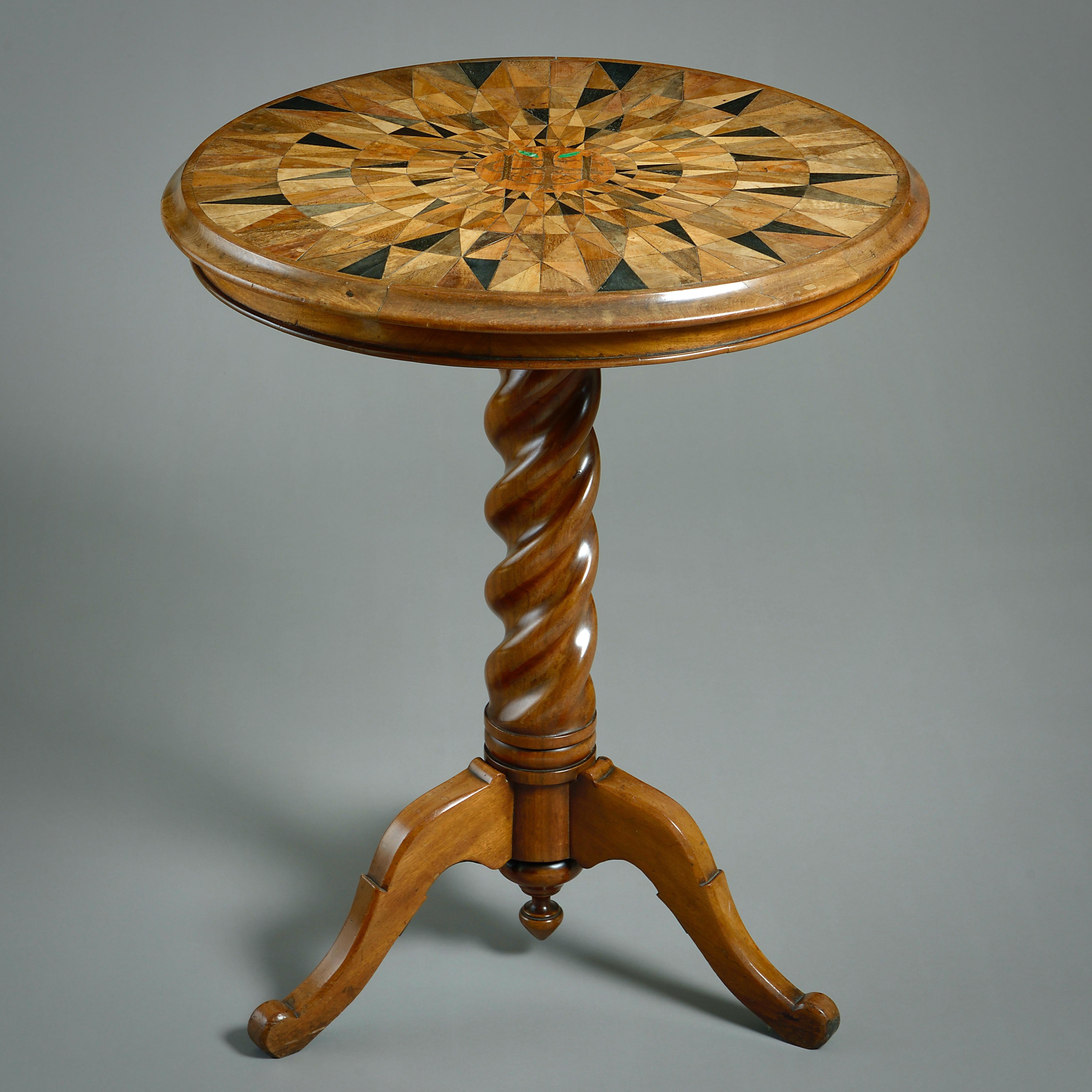 AN EARLY VICTORIAN SPECIMEN-WOOD AND MAHOGANY CENTRE TABLE, CIRCA 1850.

The circular tilt-top inlaid with various exotic woods and centred by a cipher.