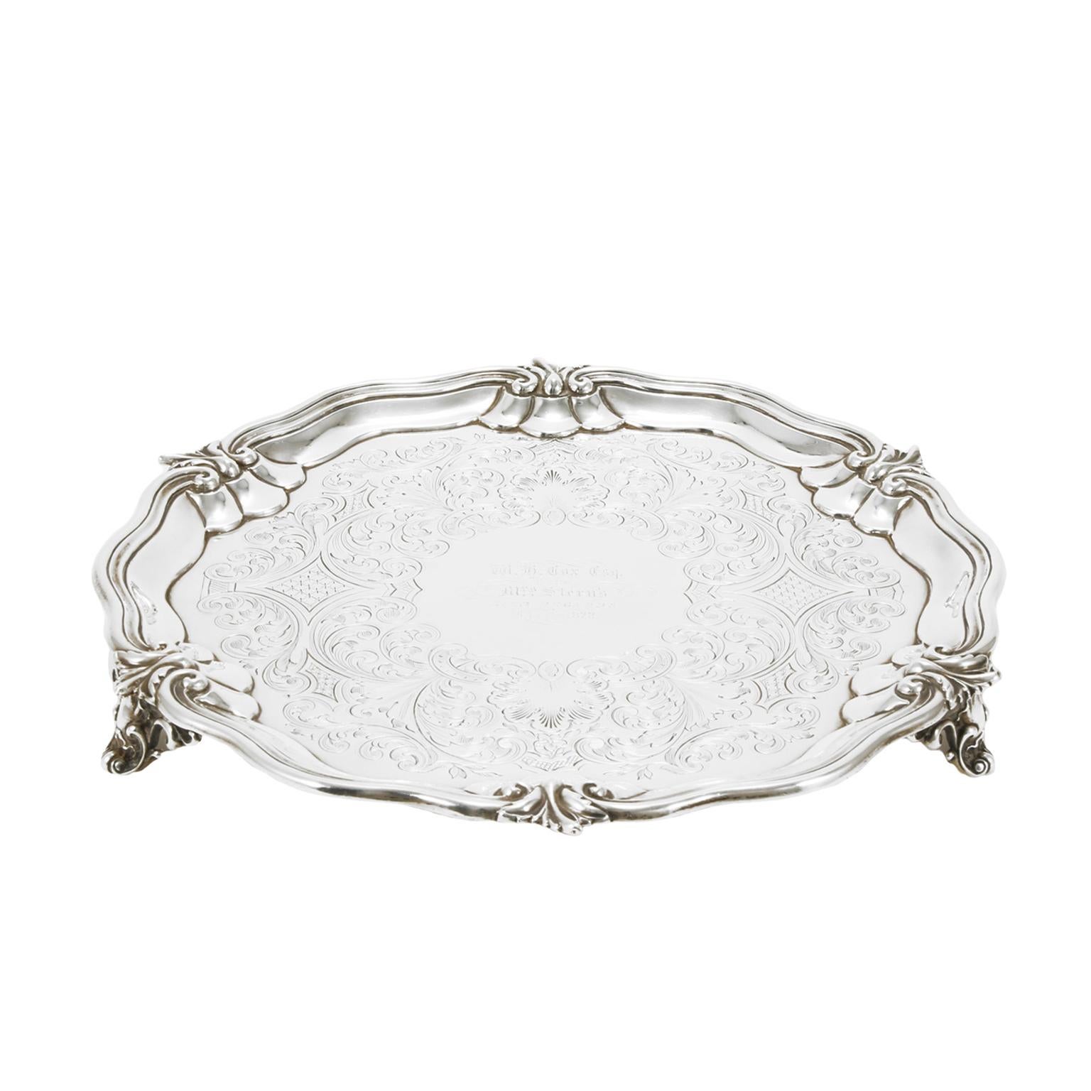 Original silver tray by Charles Reily & George Storer. Produced in 1841, in London, GB, during the Queen Victoria period. It has a contoured lip and an internal engraving with hand floral motifs and a dedication to the center. Sterling silver 925%.