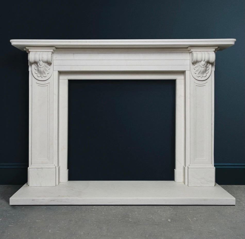 An elegant early 19th century Victorian style well carved statuary marble corbel fireplace surround. A generous top moulded shelf sits directly above a stepped frieze flanked by recessed panel jambs surmounted with deep carved bulborous scrolled