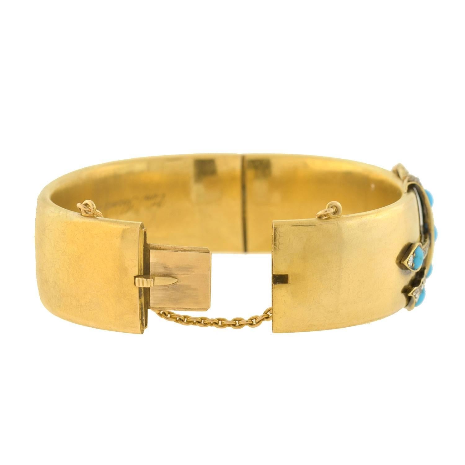 A fabulous turquoise bracelet from the Victorian (ca1869) era! Crafted in 15kt yellow gold, this wonderful piece is a hinged bangle style bracelet with a wide, flat body. At the center of the bracelet is a dynamic wrap-around motif which adorns