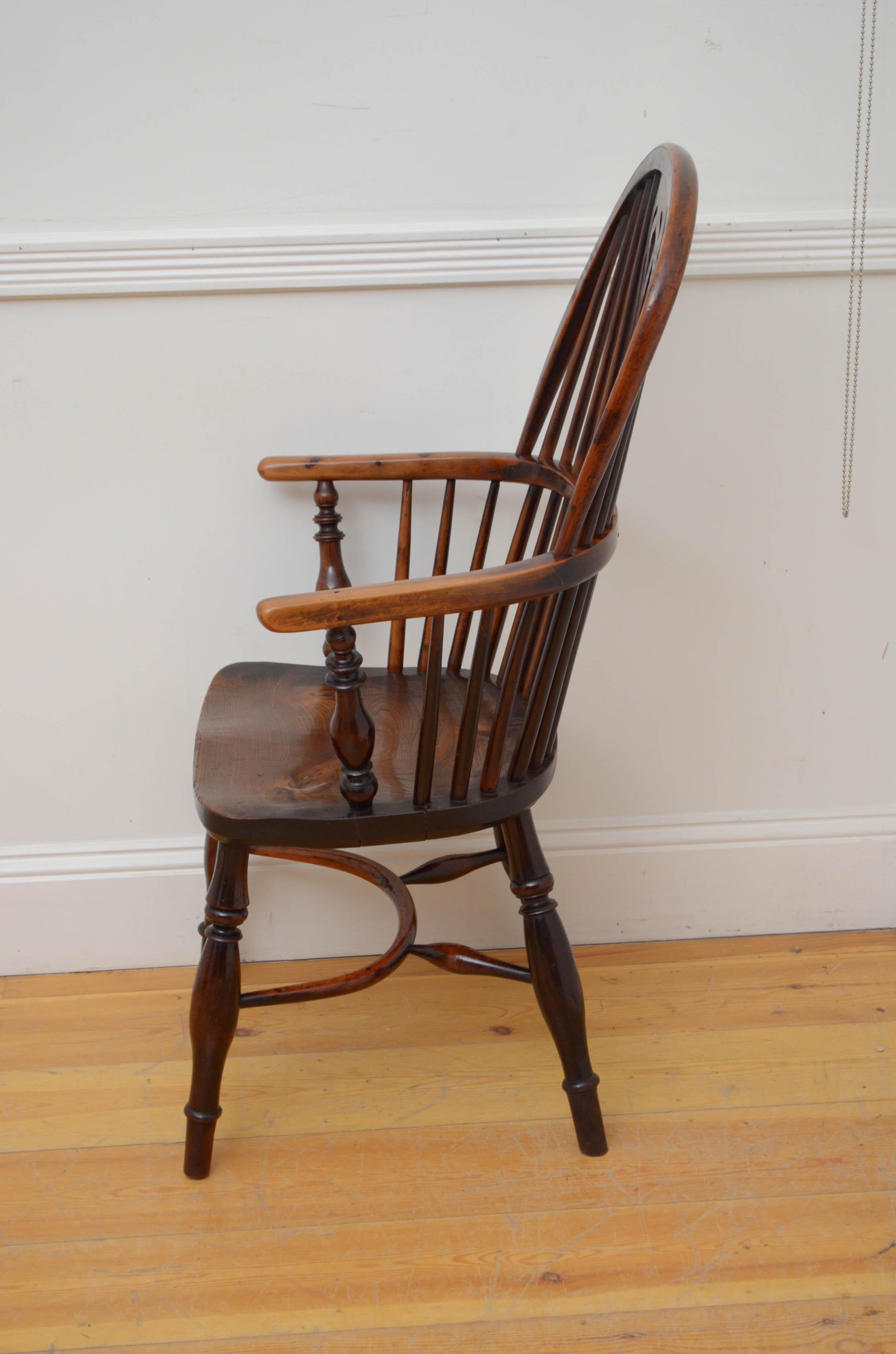 Sn5506 Early Victorian yew and elm wood Windsor chair, having arched back with centre splat flanked by spindles, open arms and shaped seat, standing on turned legs united by crinoline stretchers. This antique chair is in home ready condition.