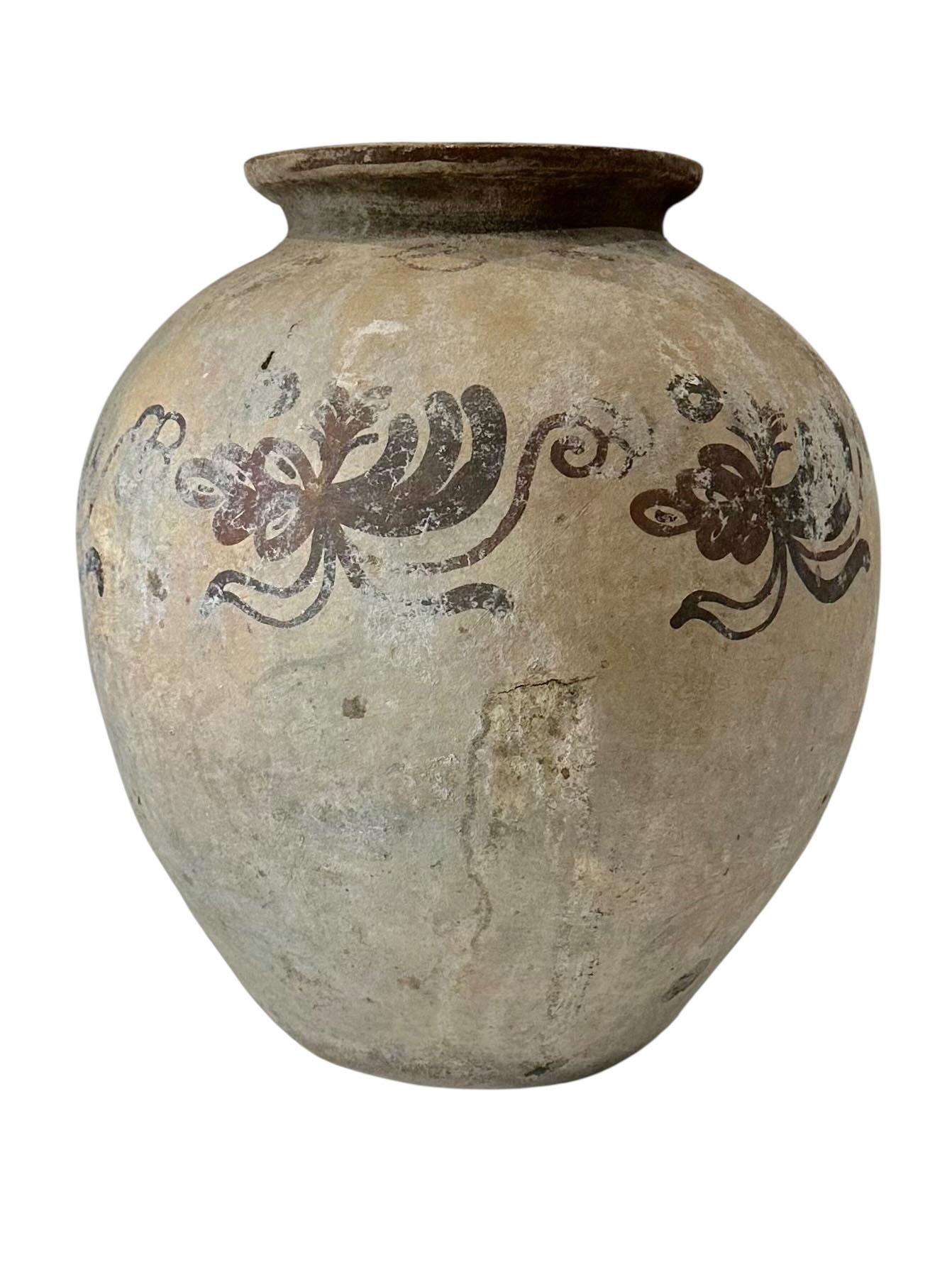 A striking and substantial example of early Vietnamese blue and white pottery, this hand thrown clay vase features a rich cobalt glaze over a creamy ground, with expressive brushwork and a softly aged surface that speaks to its age and