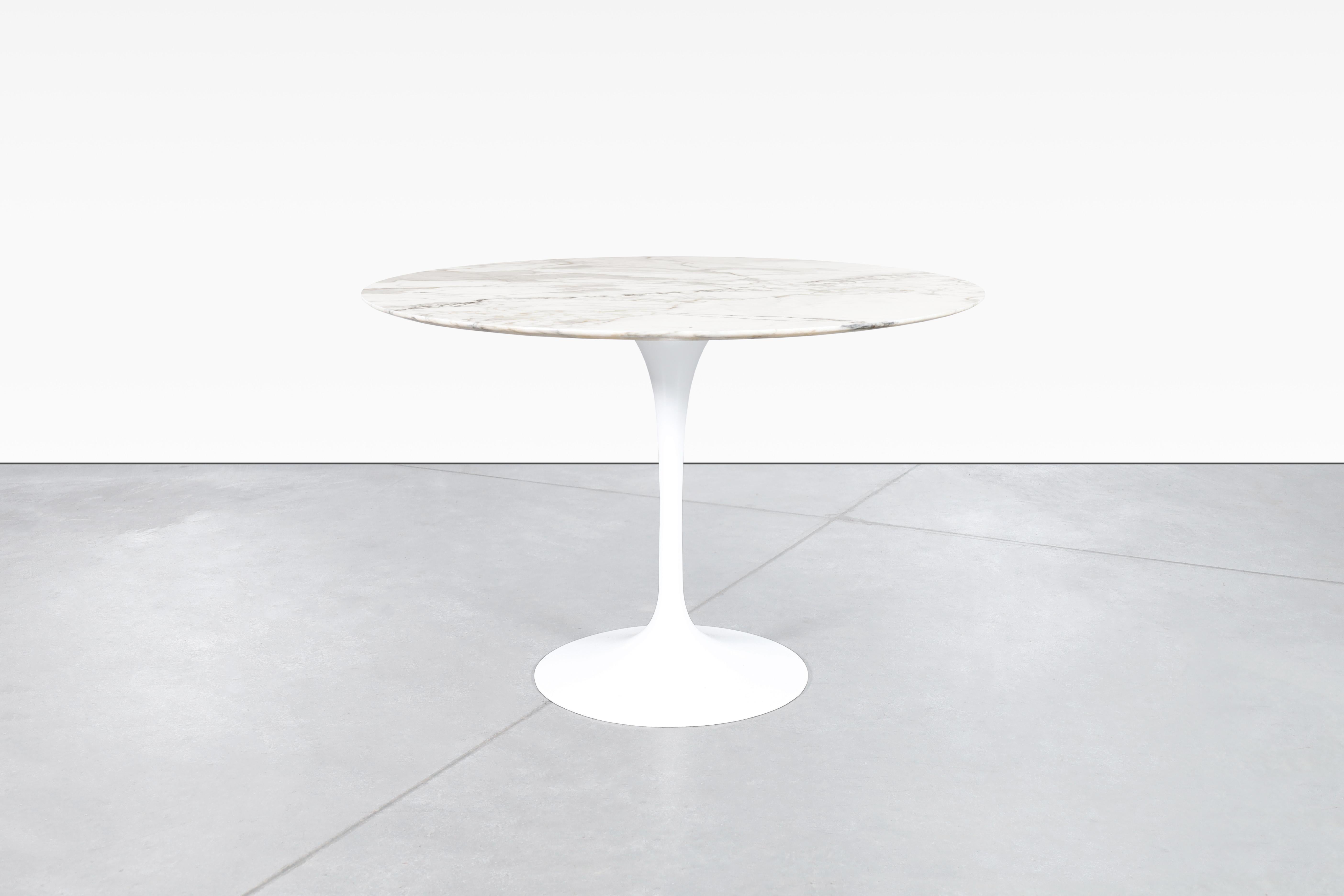 The Tulip Table by Eero Saarinen for Knoll is a timeless piece of furniture that will never go out of style. This early design features a stunning Calacatta marble top that rests atop an elegant aluminum base. The table's unique design allows it to
