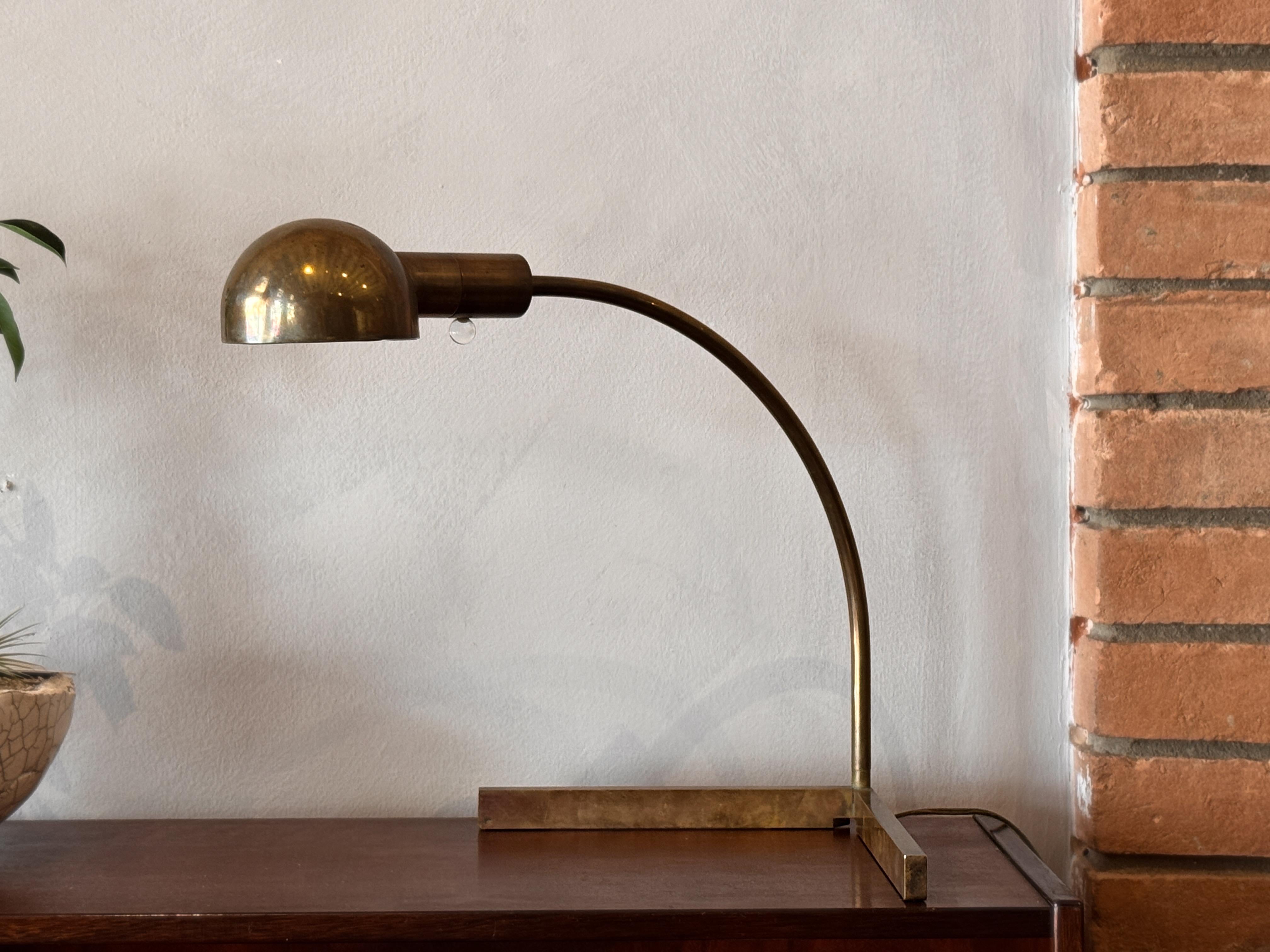 Una refinada lámpara de sobremesa de latón del célebre diseñador Cedric Hartman, con sus características líneas minimalistas y una parte superior redondeada graciosamente curvada. 

La superficie ha desarrollado una cálida pátina natural, que realza