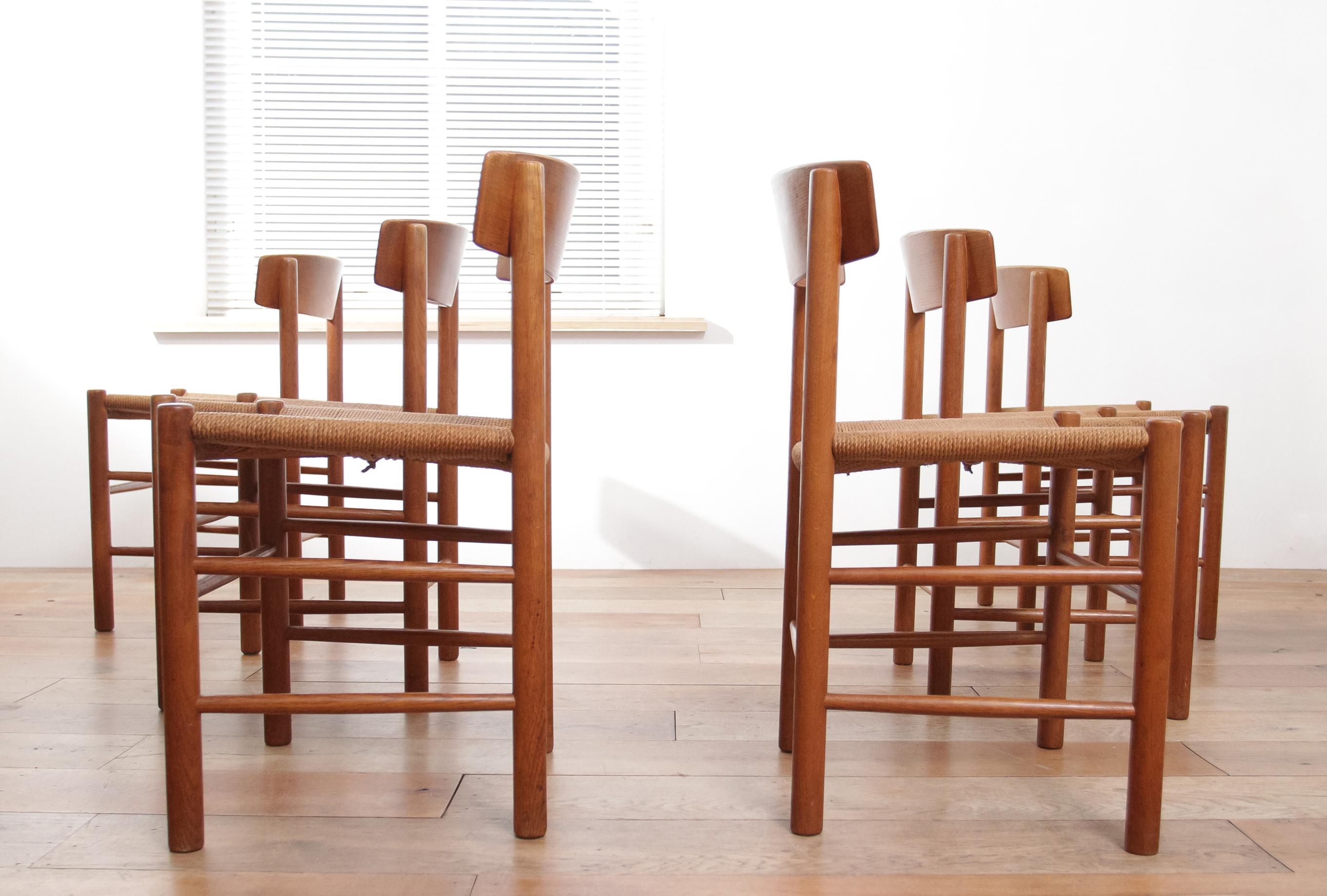 Die abgebildeten Stühle sind ein Musterbeispiel für skandinavisches Design, wahrscheinlich die J39-Esszimmerstühle, die der dänische Möbelhersteller Børge Mogensen um 1960 entworfen hat. Die Stühle zeichnen sich durch ihre schlichte, aber elegante