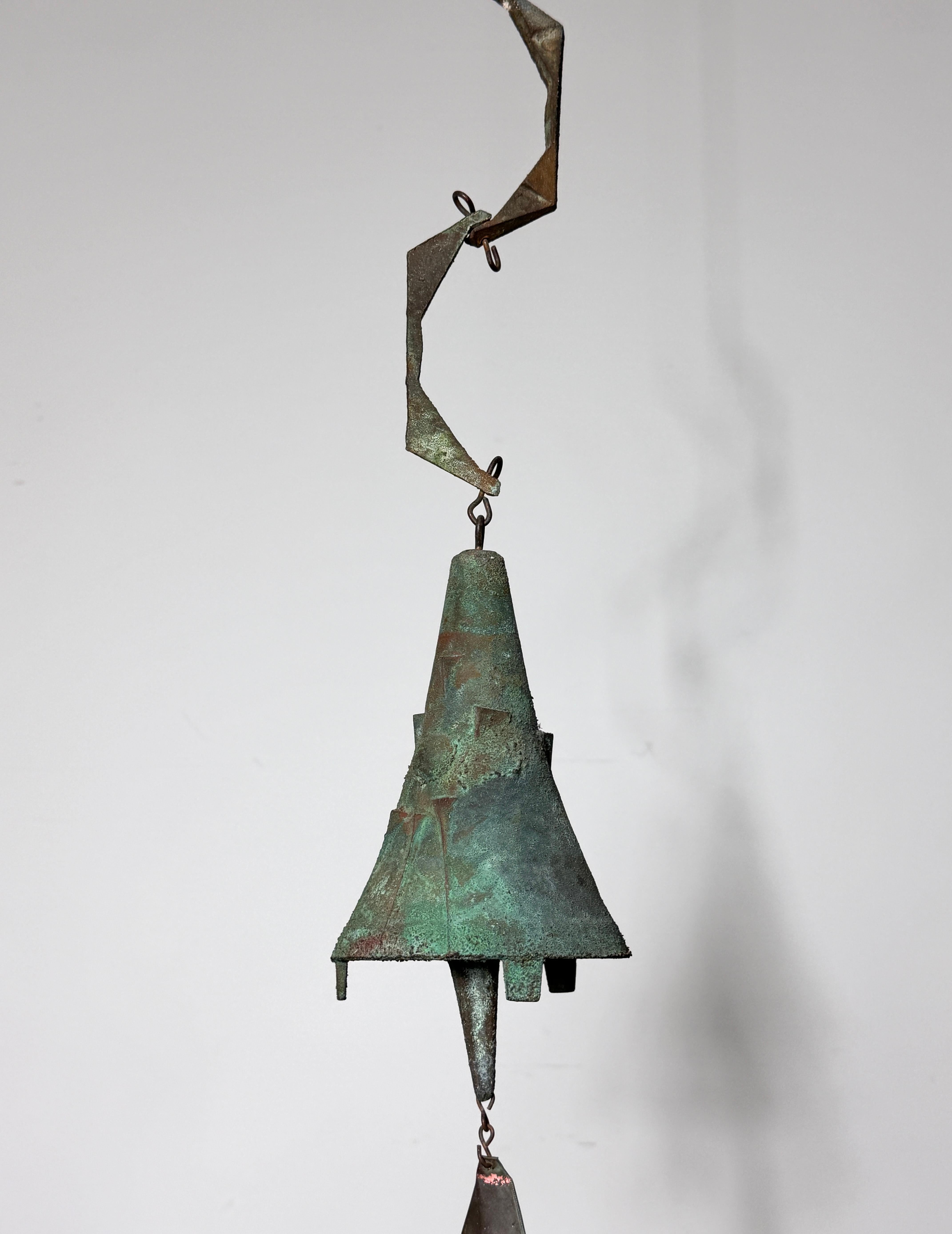 Early cast bronze brutalist wind bell by Paolo Soleri for Arcosanti 
Circa 1970s

Great form with uncommon modernist sun pattern exaggerated chain and original copper fin
Signed 

Overall height w/ chain 26 inches
Bell diameter 5 inches