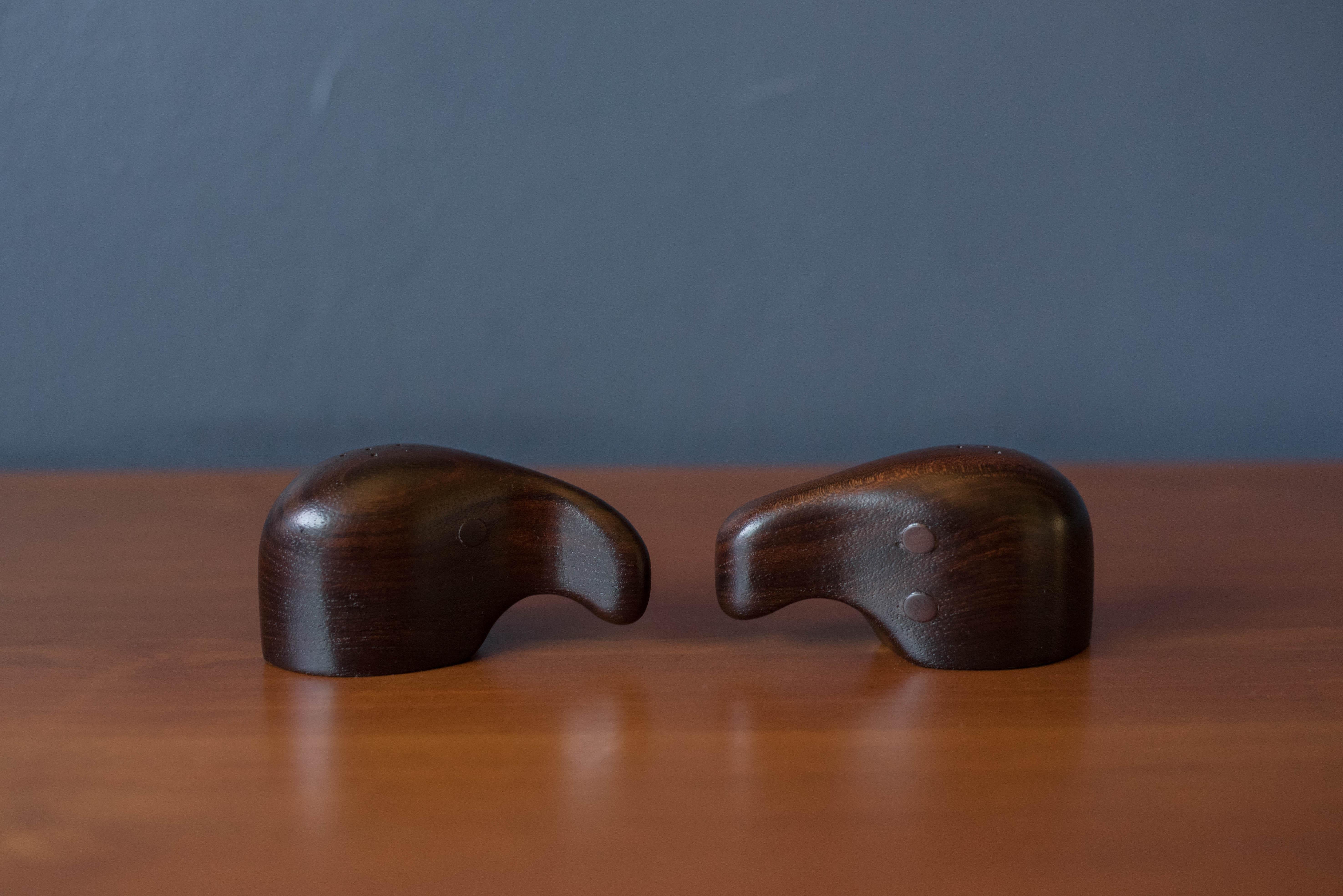 Mid-Century Modern abstract salt and pepper shakers designed by Don Shoemaker for Señal, S.A. Mexico. This set is handmade in rosewood with unique brass ring dispensers that makes for a standout tabletop setting. Each shaker is numbered and