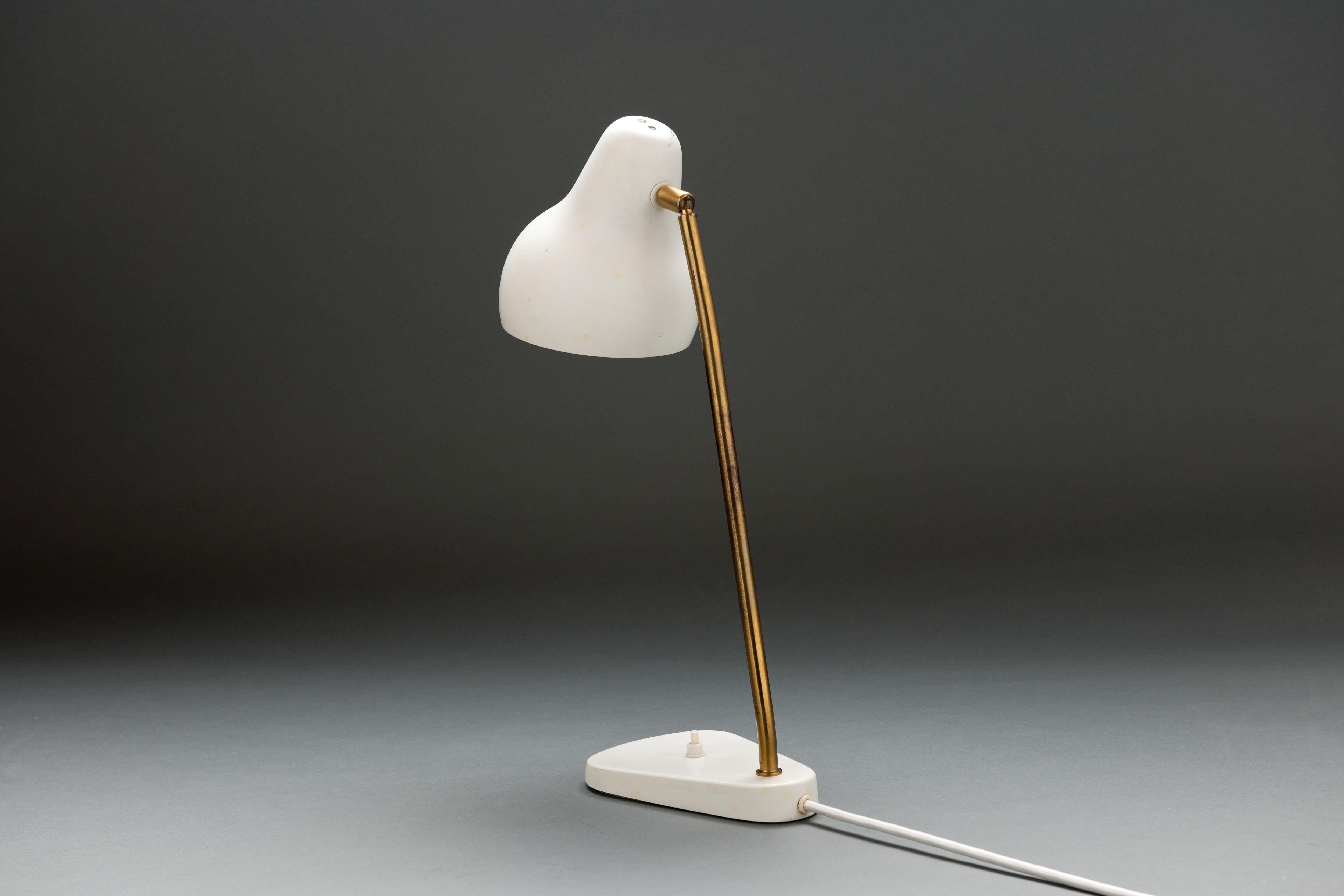 Lampe de table du début des années 1950 du designer et architecte danois Vilhelm Lauritzen (1894 - 1984), fabriquée par Louis Poulsen, Danemark.
Hotte de forme organique en acier blanc mat sur une tige en laiton avec articulation à rotule permettant