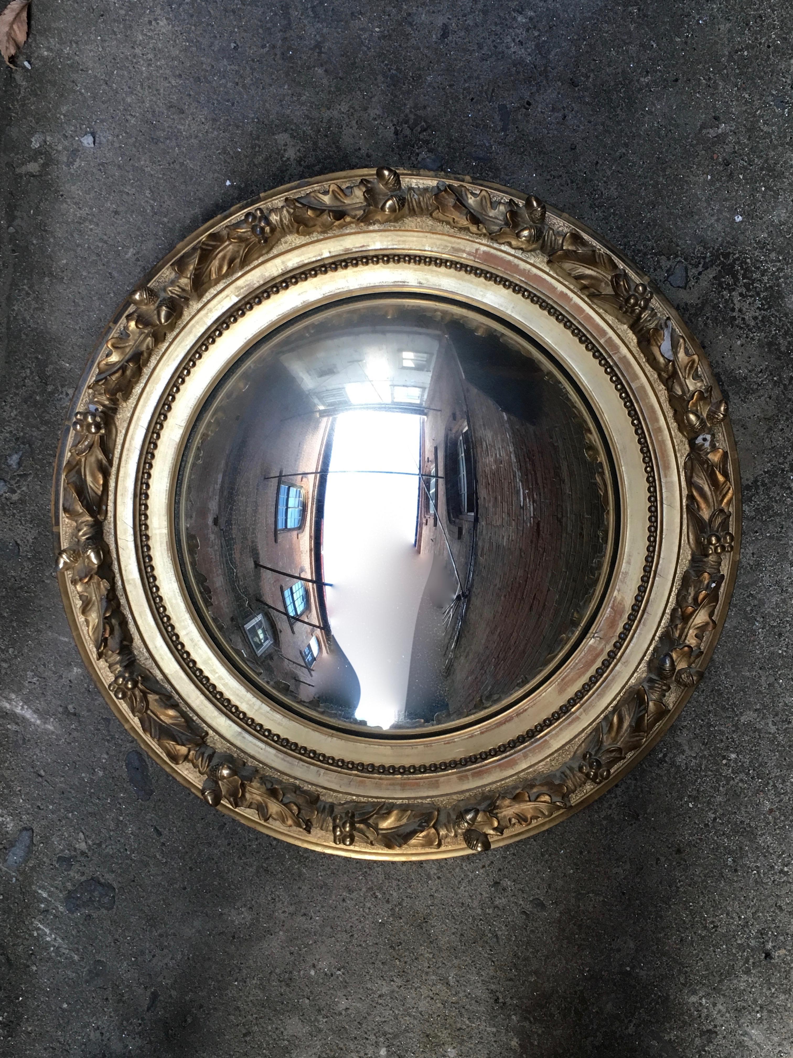 Beautiful and sumptuous water gilded acorn, leaf and berry motif convex mirror. Wonderful high relief detail of the cast gesso frame, circa 1860-1890. Grey blue bole. Beading detail on fillet. Mirror is backed by a thick piece of wood board and old