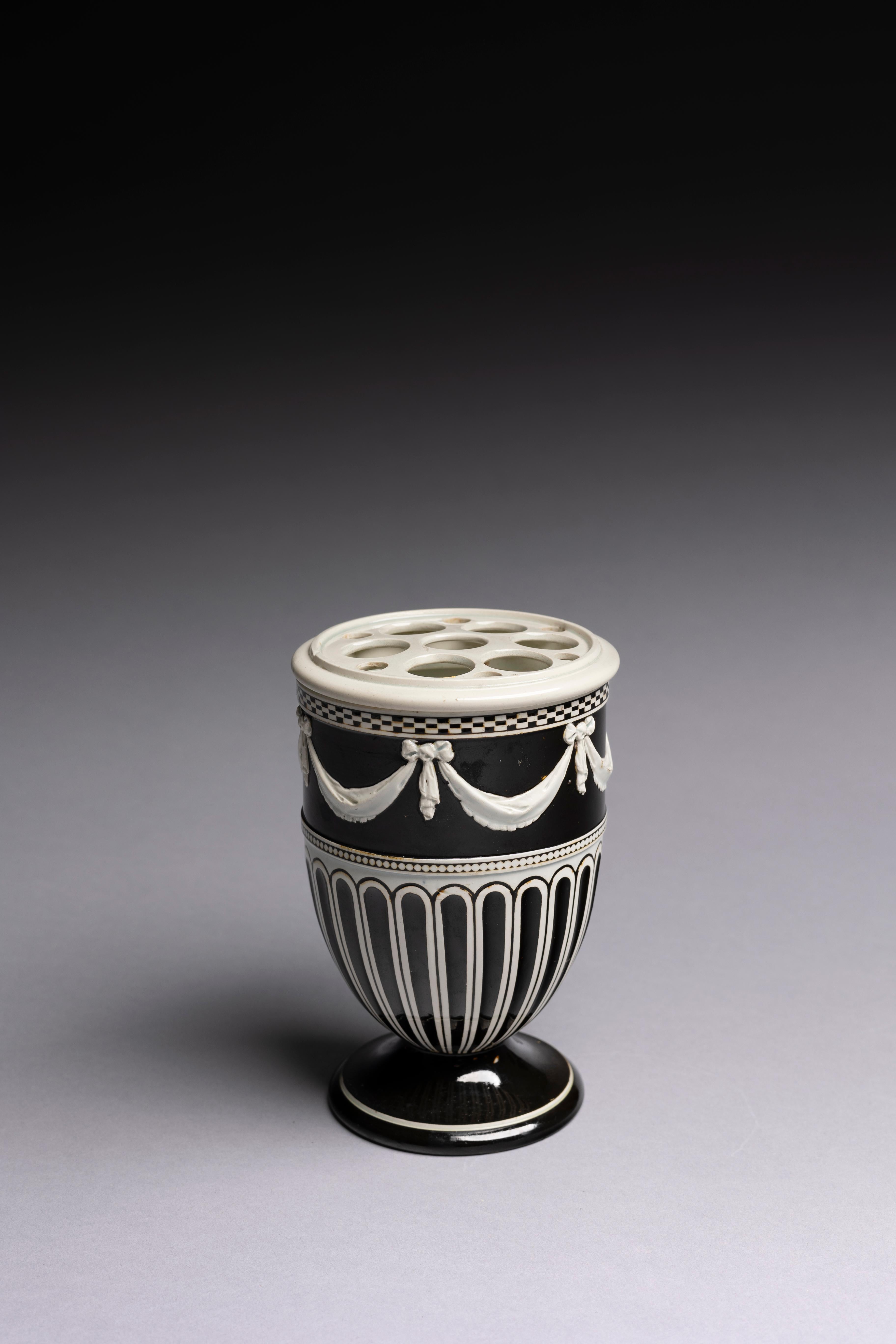 Un pot à branches en faïence perlée à glaçure brune foncée avec couvercle percé et décoration appliquée, fabriqué par Wedgwood vers 1785.

Depuis des centaines d'années, les céramistes du monde entier ont cherché à créer une surface pure sur