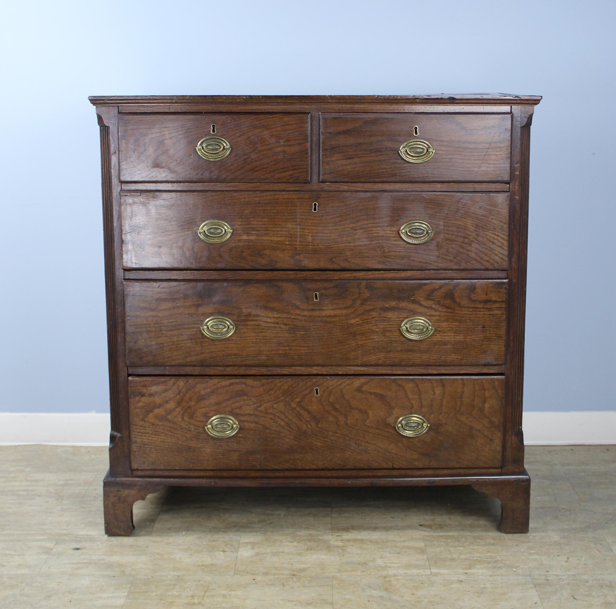 An early Welsh chest of drawers with original handles and stylized ogee feet. Classic two-over-three construction and generously proportioned. Note the fine reeded quarter-columns. Interiors of the drawers are very clean for the age of the piece. 