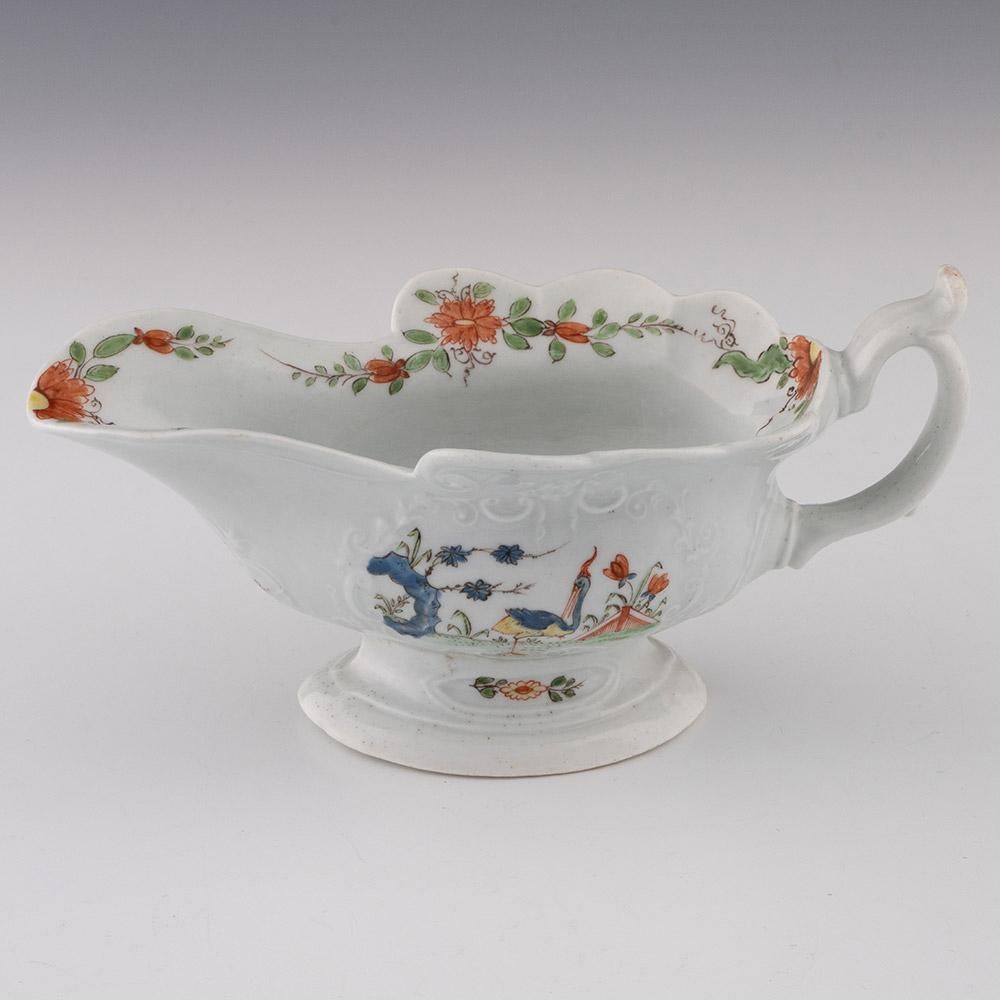 Heading : Worcester porcelain sauce boat with strutting birds
Date : 1753-1755
Period : George II
Origin : Worcester, England
Colour : Polychrome
Pattern : Floral polychrome band to rim, decorated cartouches to sides with exotic birds with