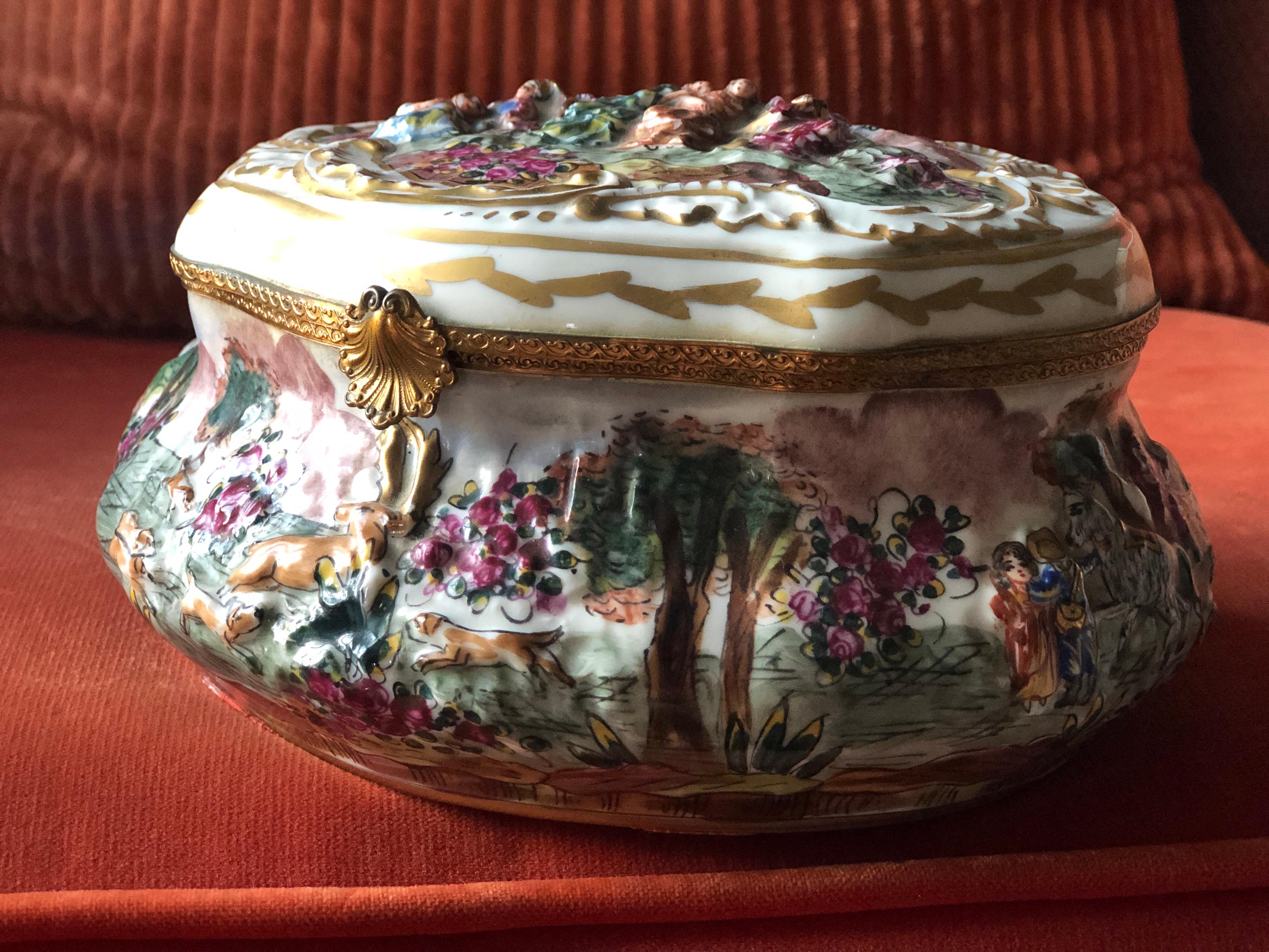 Beautiful porcelain antique box Capodimonte richly decorated with colourfully painted raised figures all around the piece and with small floral paintings inside the box. Very good condition with no restorations.
Italy, circa 1920.