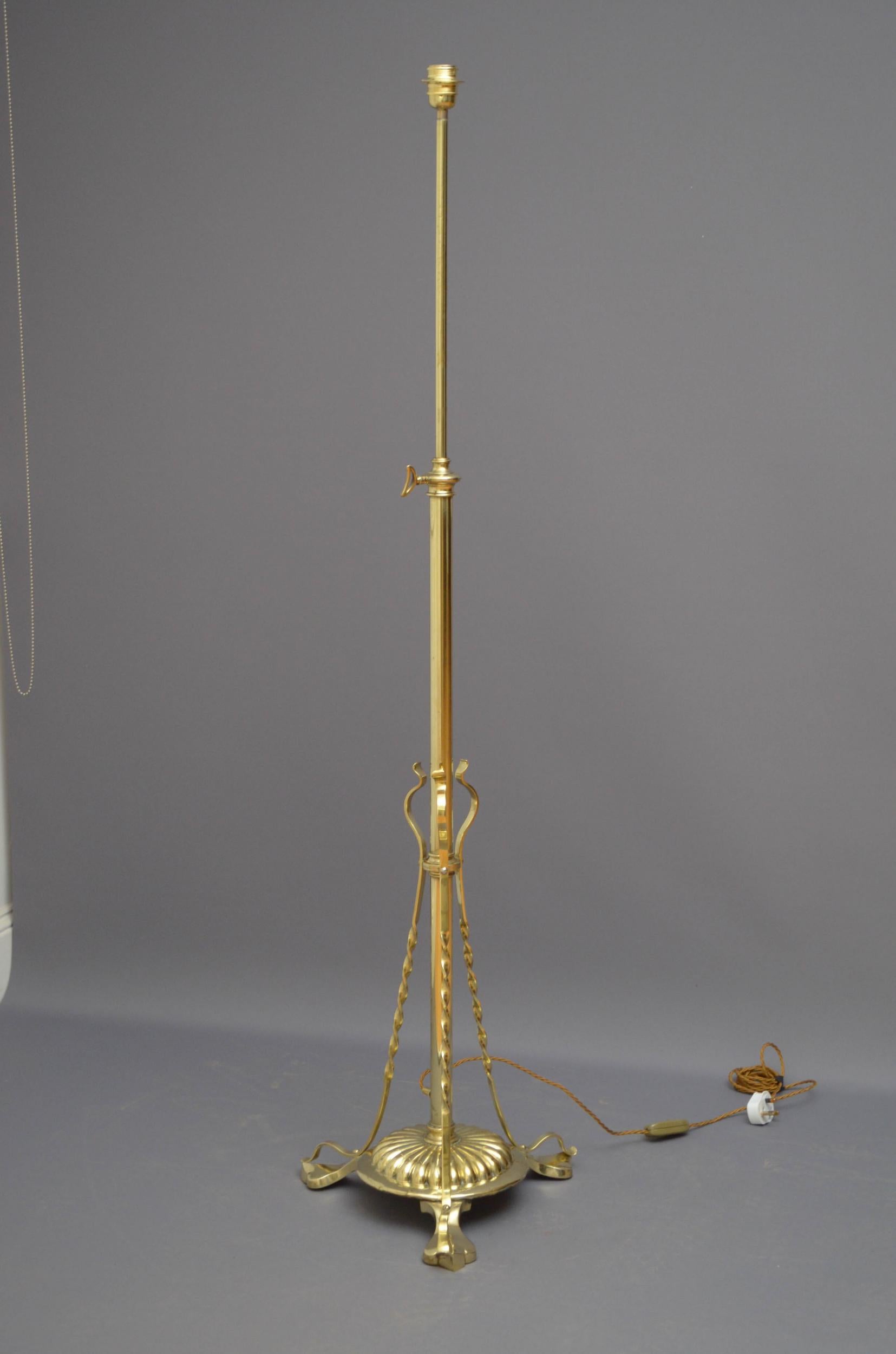 Sn4888 early 20th century brass standard lamp with height adjustable mechanism and circular fluted base with three twisted supports and pad feet. This antique lamp has been cleaned, polished and professionally rewired, all in home ready condition.