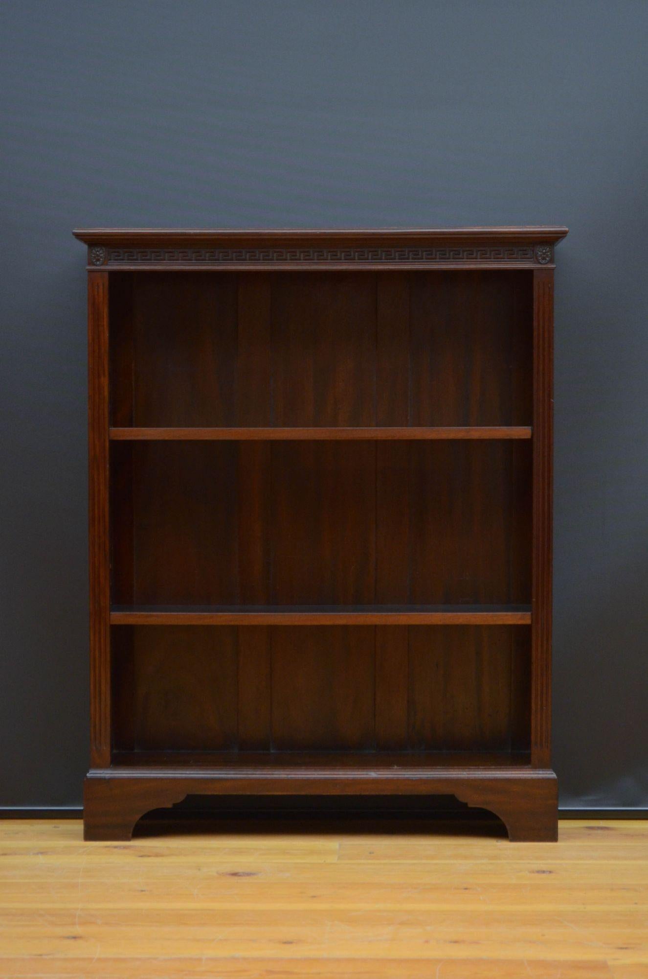 Early 20th century solid mahogany open bookcase, having oversailing top with moulded edge above very attractive Greek key carved frieze and two height adjustable shelves, all flanked by reeded pilasters and carved paterae, standing on shaped bracket