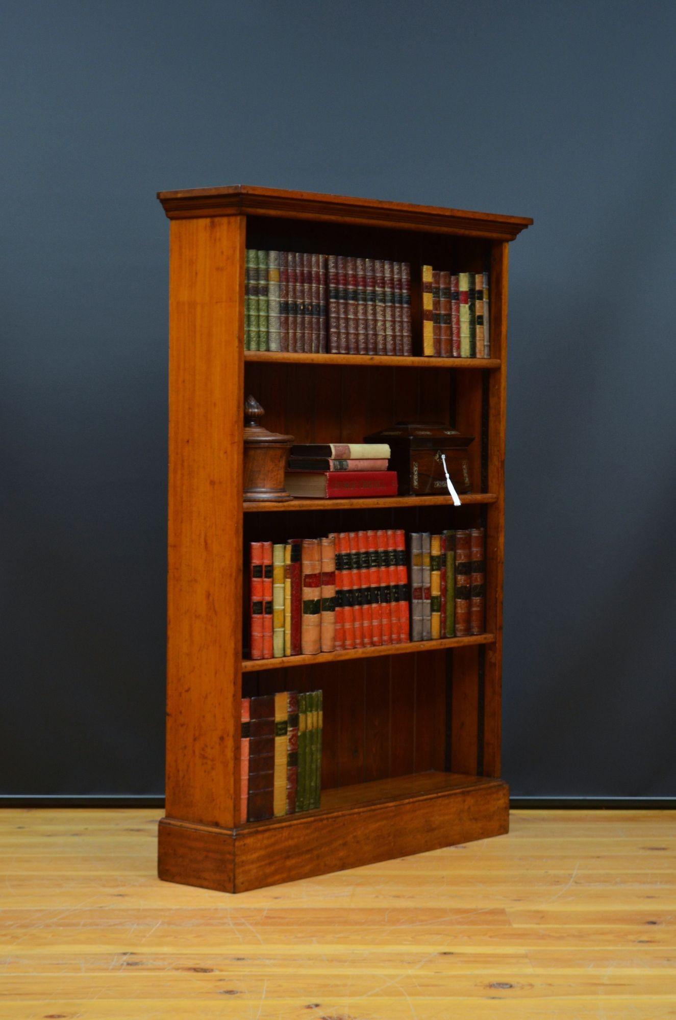 K0623 Early 20th century, solid mahogany open bookcase of unusually narrow proportions, having figured mahogany, oversailing top above three solid mahogany shelves and solid mahogany sides, all standing on plinth base. This antique bookcase is in