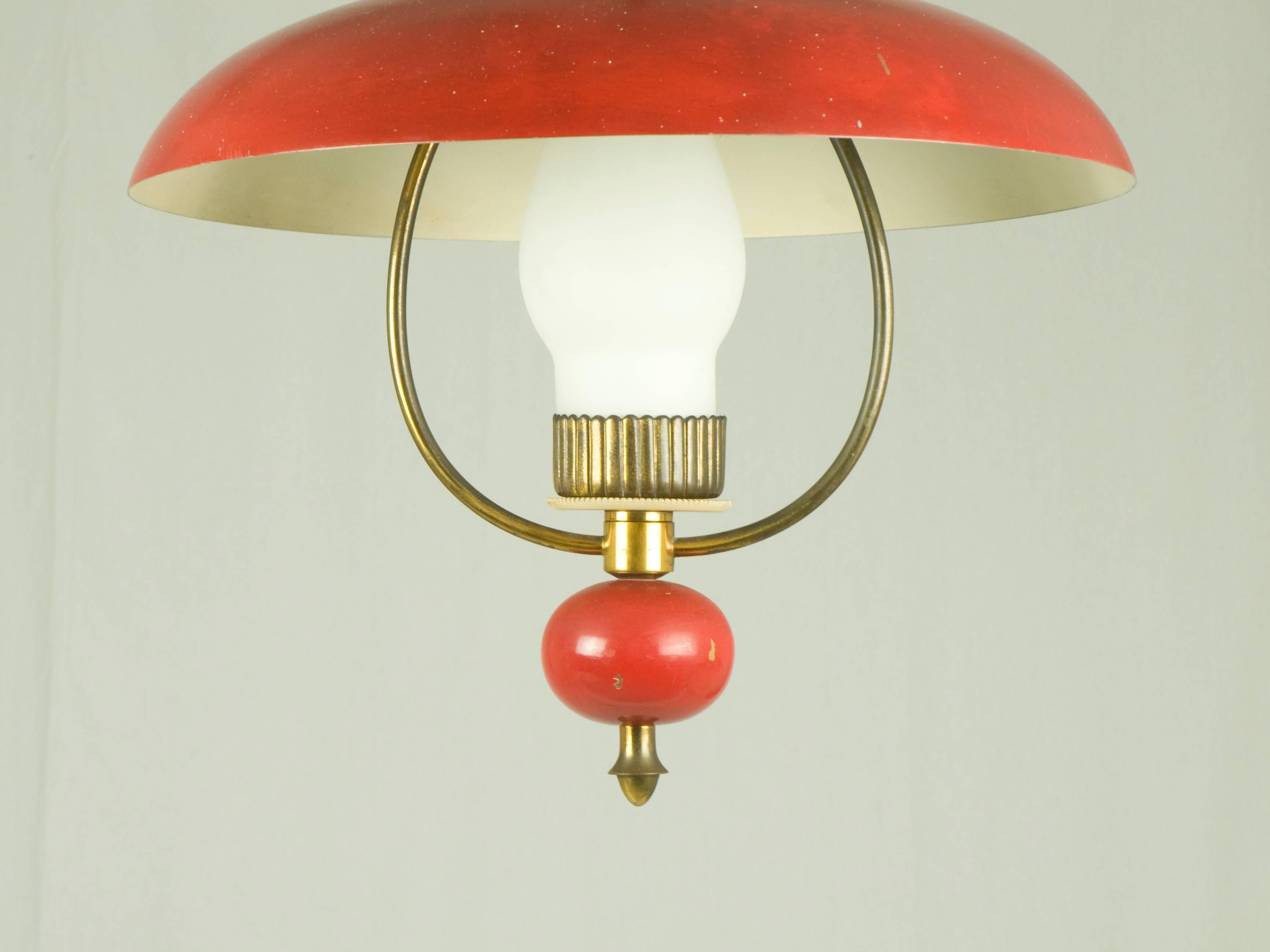 This pendant was produced in Italy by Stilnovo in the late 1940s. It is made from a red lacquered metal with a brass structure and features a sandblasted glass shade. The lamp belongs to the first Stilnovo production: Yellow label inside the shade