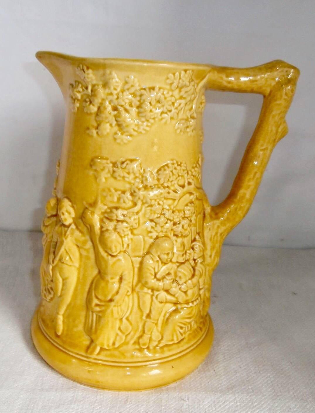 Early large rustic yellow Majolica pitcher with a tavern scene signed Sarreguemines, circa 1870.