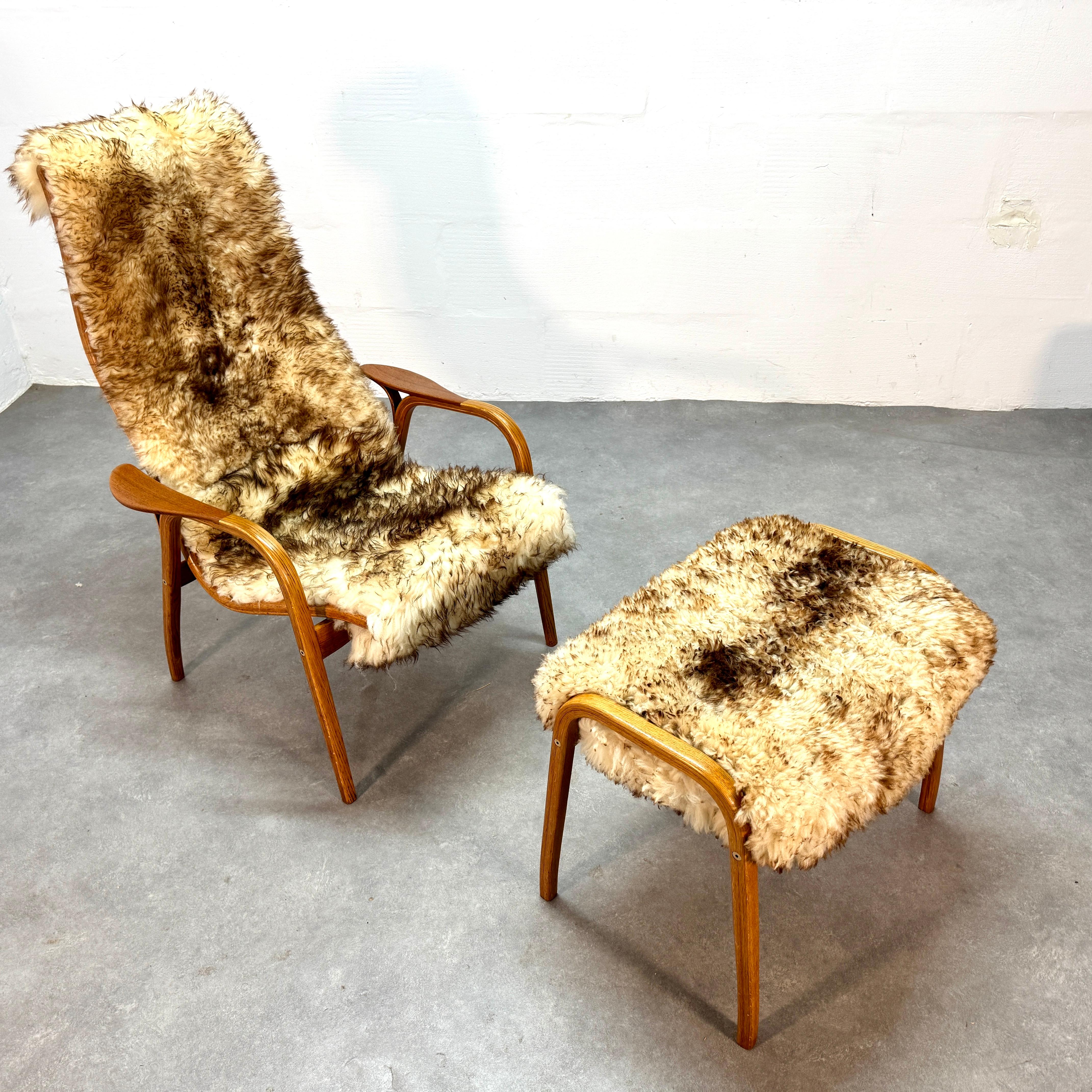 This is an early example of the iconic Lamino chair & footstool (2) by Yngve Ekström.

This chair & ottoman offered ticks all the boxes for the perfect set.

- Natural 'stracciatella' fluffy sheepskin (brown not black)
- Duo tone, Oak frame with