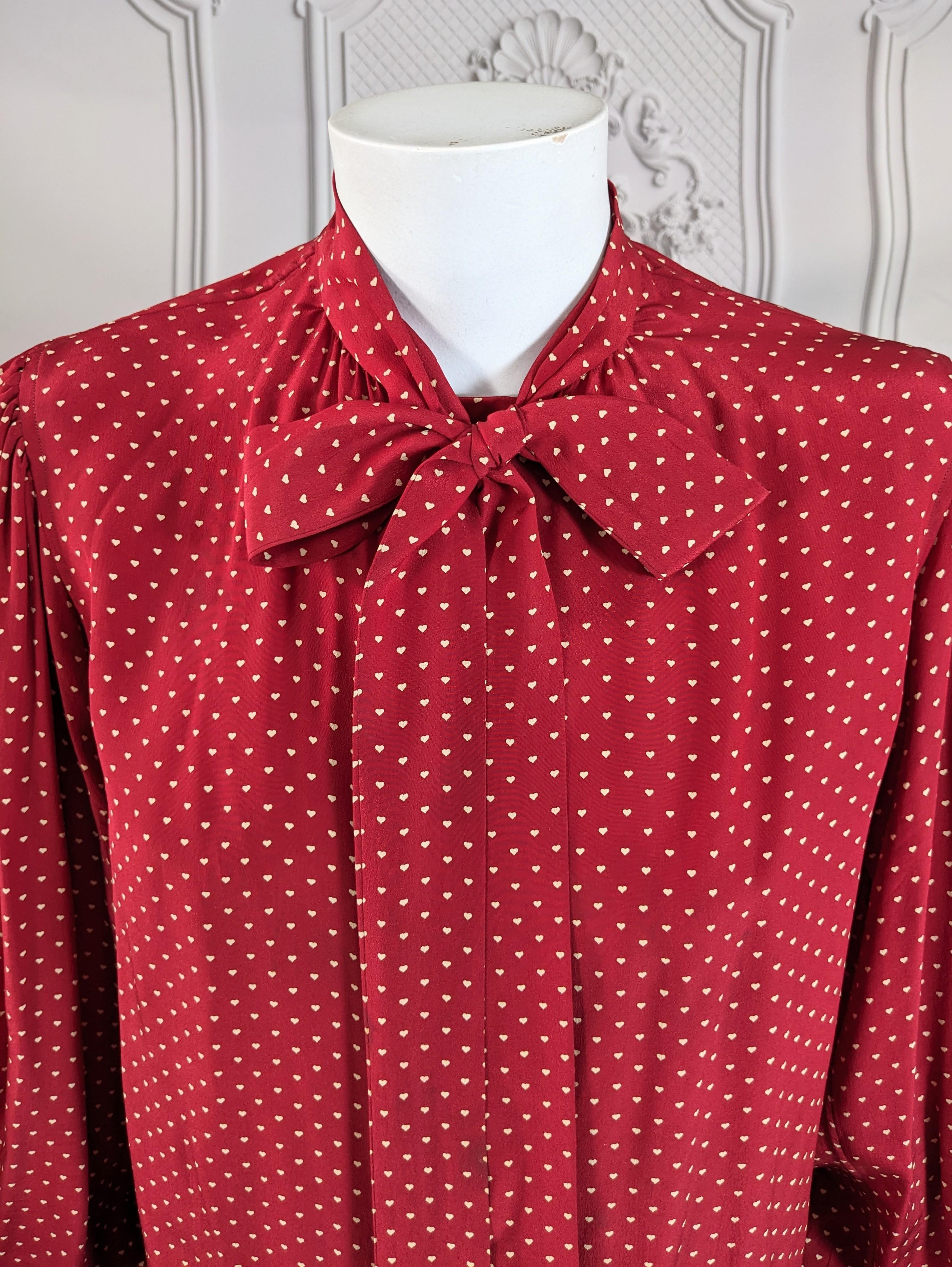 Rare Yves Saint Laurent Heart Print Bow Blouse from the 1970's. Deep cherry silk crepe with tiny heart print, long bow ties and full sleeves. Covered button placket. Left bank Paris vibes circa 1970 in blouse form. Size 34 Vintage. 1970's France. 