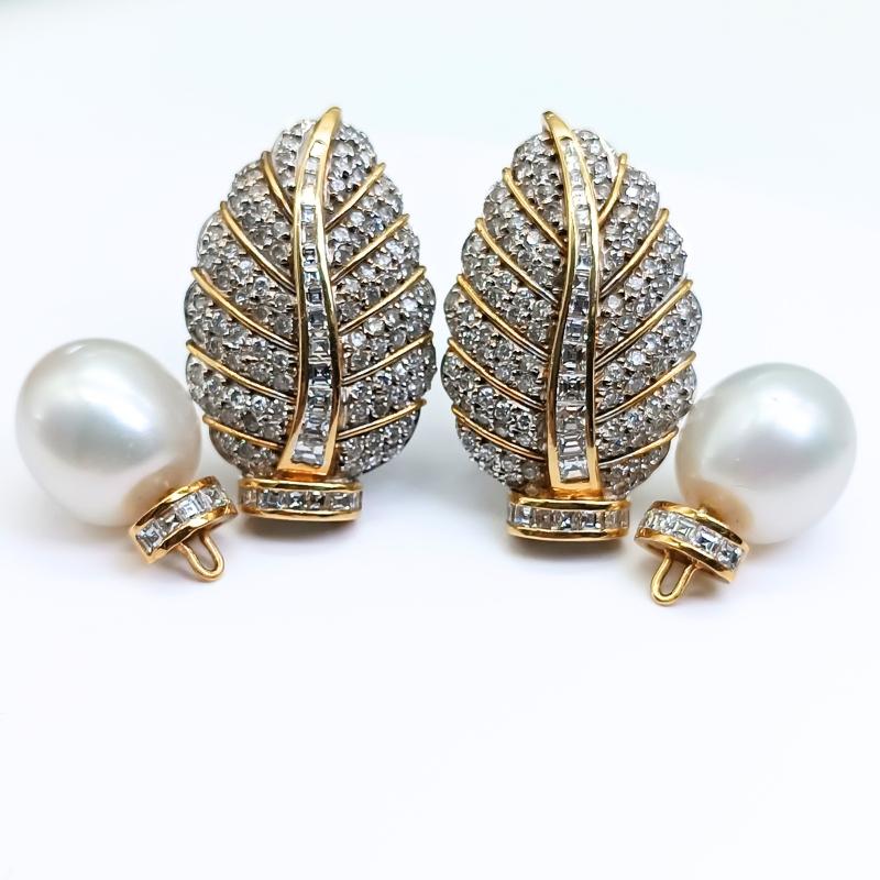 Orecchini in oro bianco e giallo con chiusura Omega.
A forma di foglia, 202 diamanti taglio brillante, 54 diamanti taglio carrè e due perle australiane.
Con la possibilità di rimuovere e inserire le perle.

Oro bianco e giallo 18k
202 Diamanti