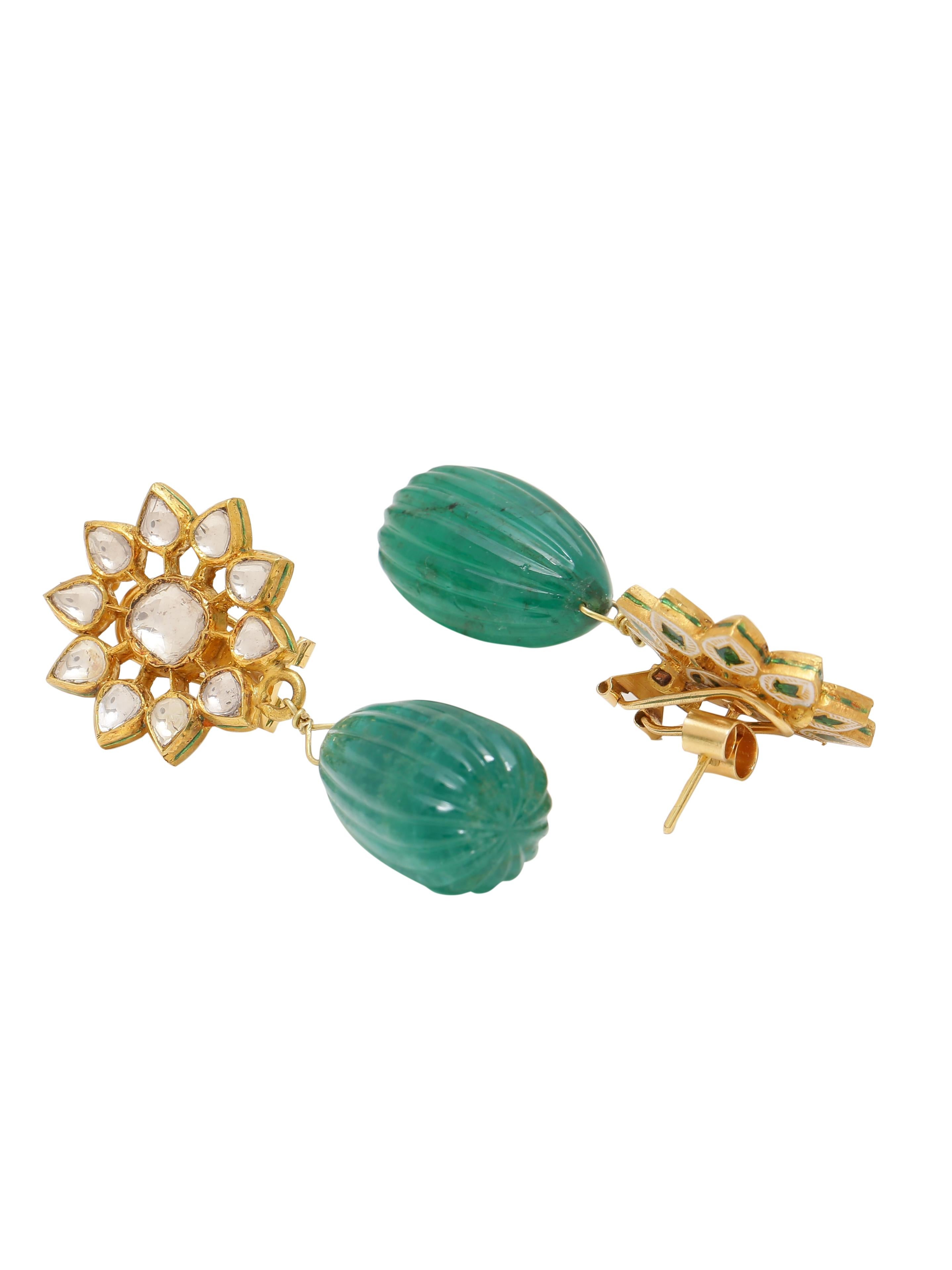 A beautiful pair of Earrings with a Flower top with Flat Diamonds set in 18k Gold and a pair of magnificent Natural Carved Emerald Drop hanging. The Emerald pair weighs 101.40 carats together and is certified from a renowned laboratory in India.
The