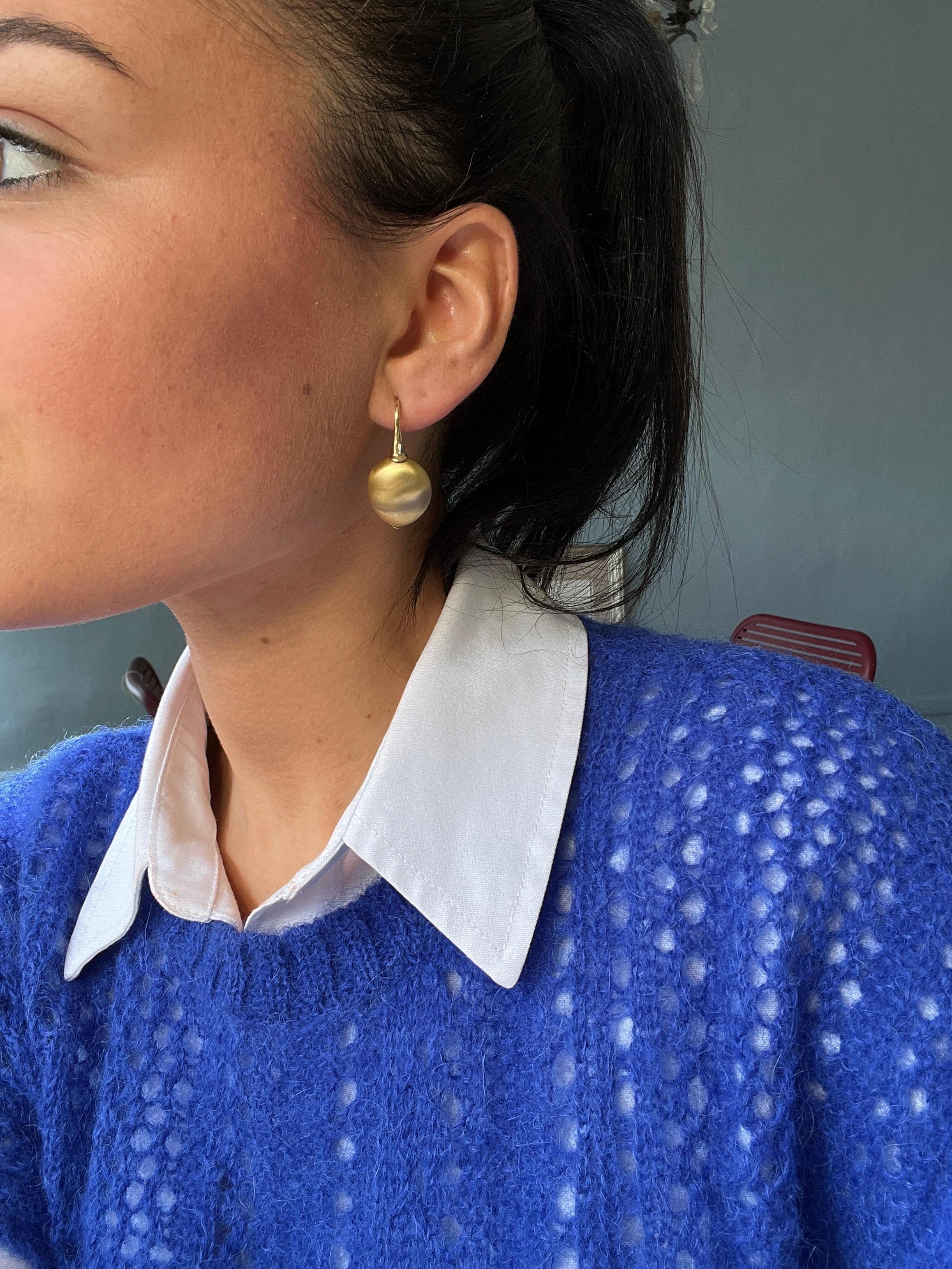 Earring Yellow Gold 18 Carat

These oval-shaped dangling earrings are distinguished by their brilliance. Crafted in 18-carat yellow gold, they feature a brushed finish for a subtly matte, softened texture. This brushing creates a refined contrast,